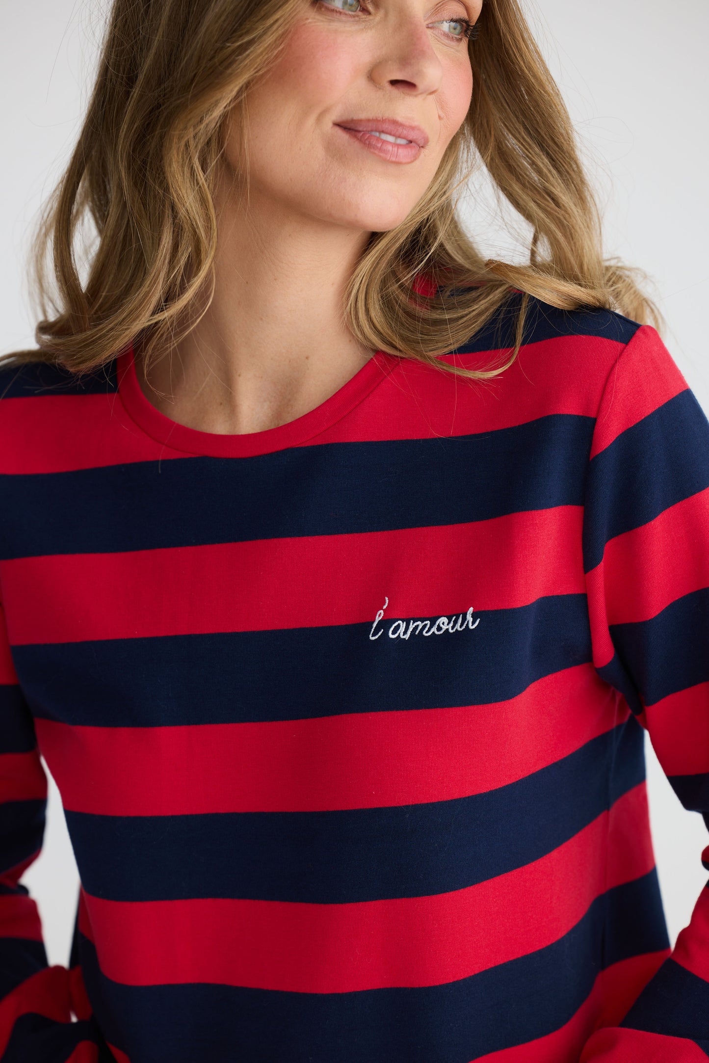 Model wearing Roam Tee Red and Navy Stripe with long sleeves and striped finish, detail view on white background