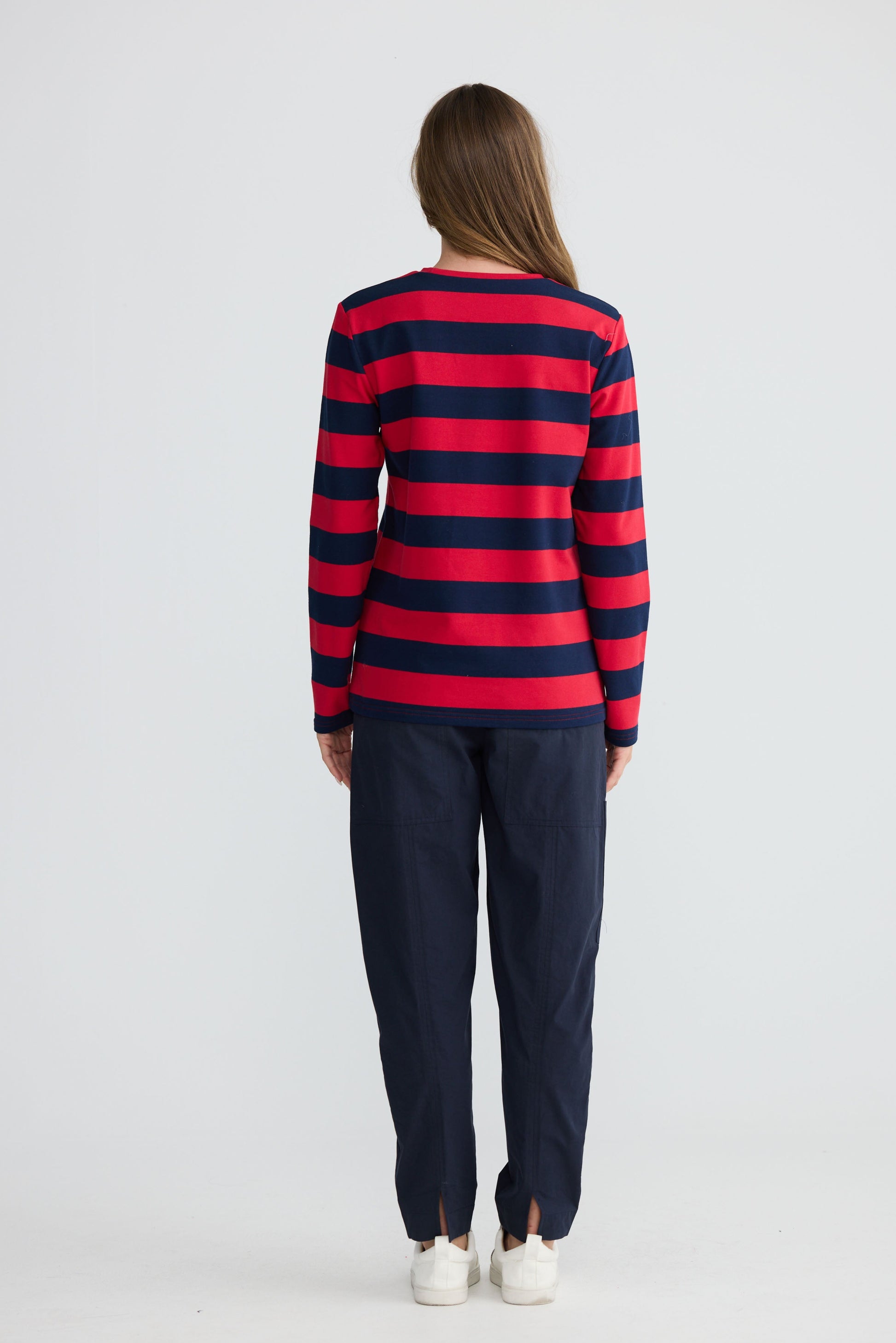 Model wearing Roam Tee Red and Navy Stripe with long sleeves and striped finish, alternate view on white background
