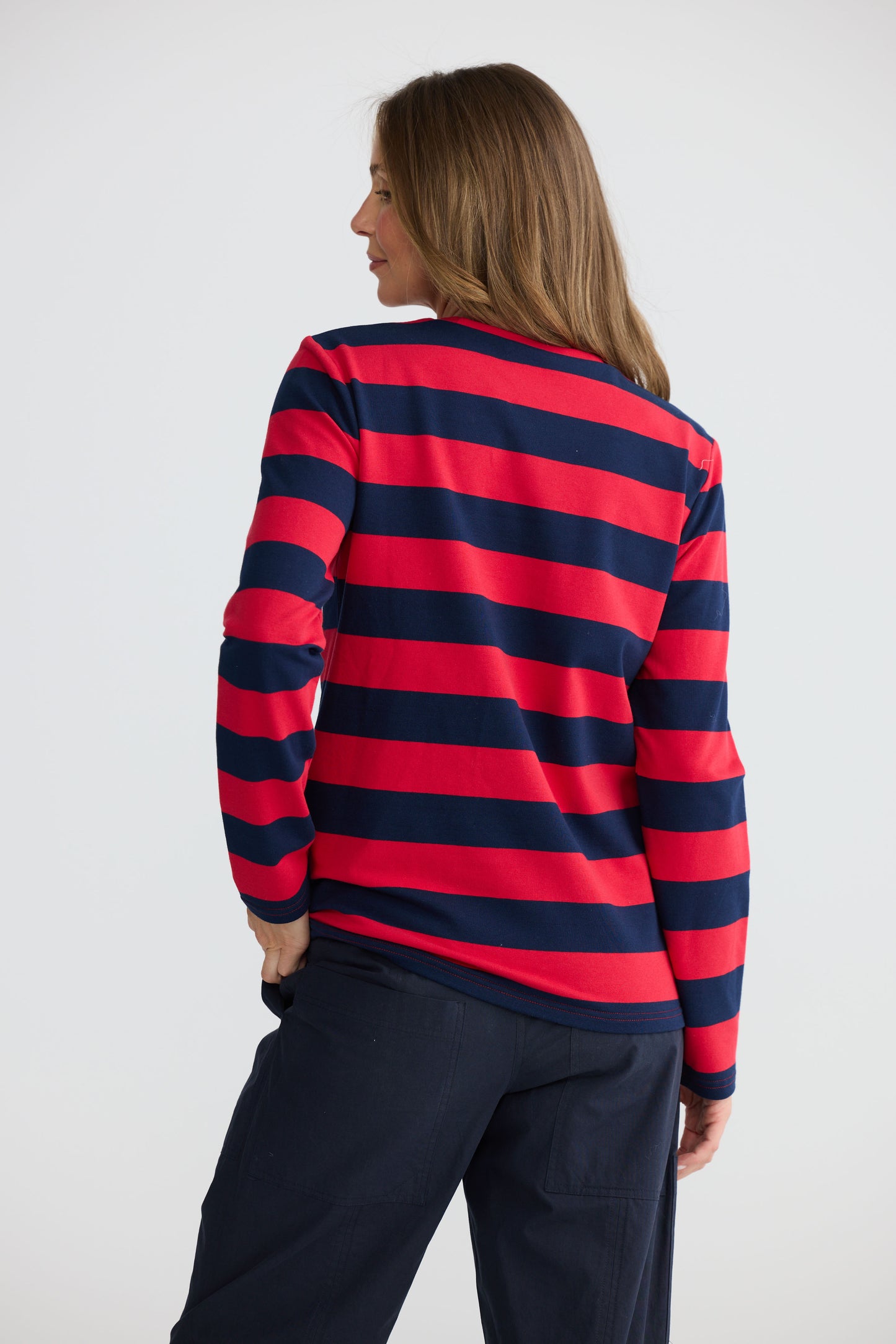 Model wearing Roam Tee Red and Navy Stripe with long sleeves and striped finish, back view on white background