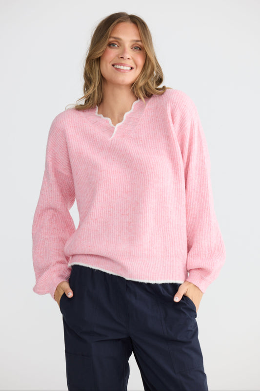 Model wearing Ocean Knit Pink with scalloped V-neckline, back view on white background