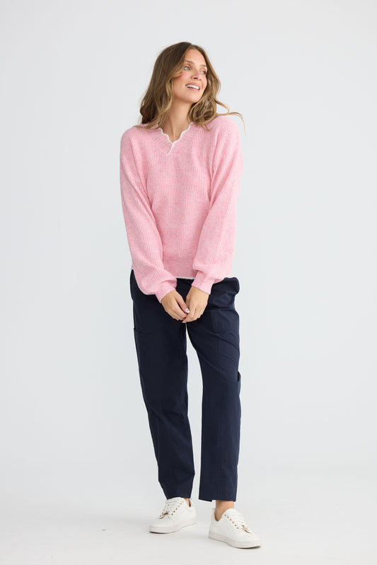 Model wearing Ocean Knit Pink with scalloped V-neckline, detail view on white background
