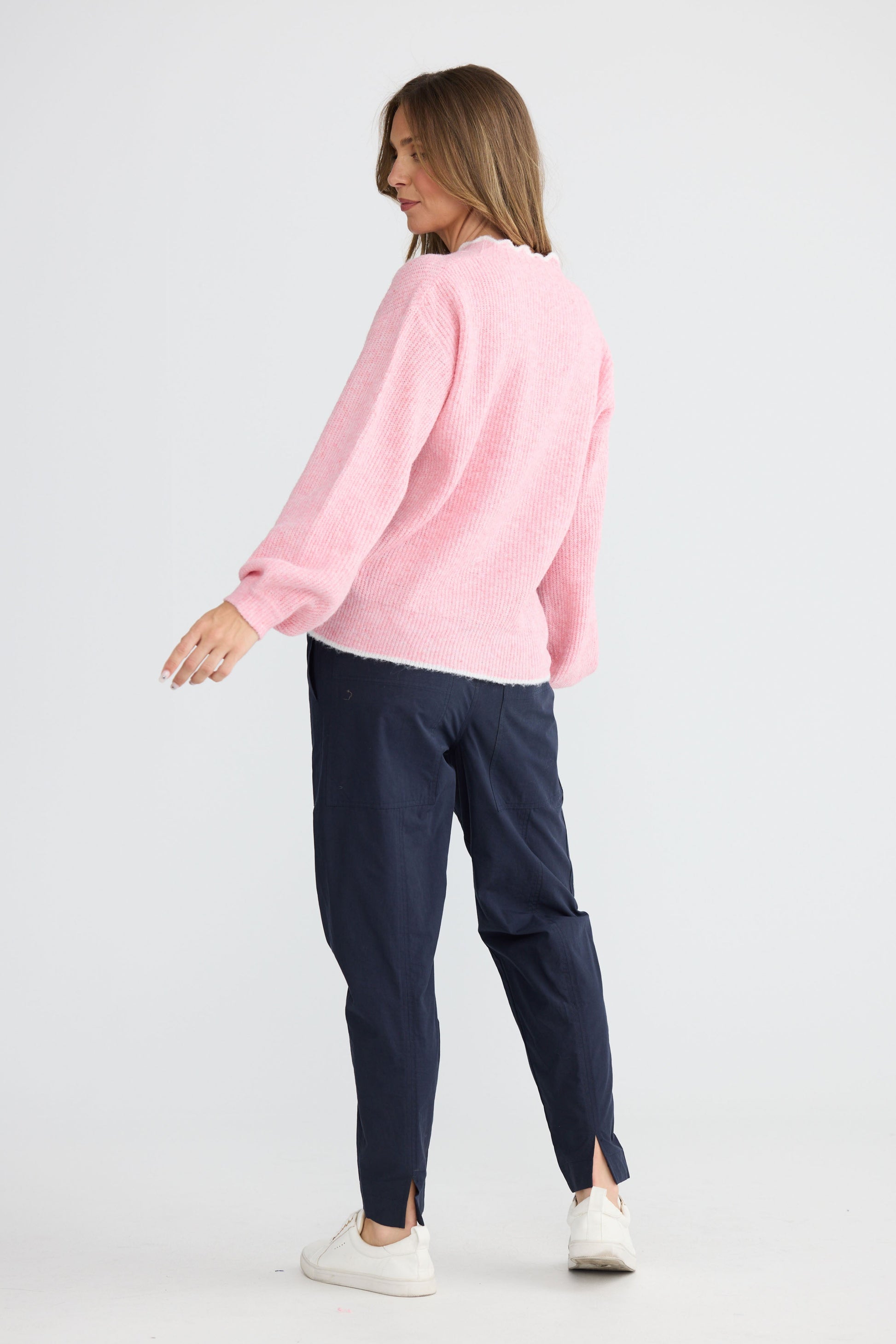 Model wearing Ocean Knit Pink with scalloped V-neckline, front view on white background