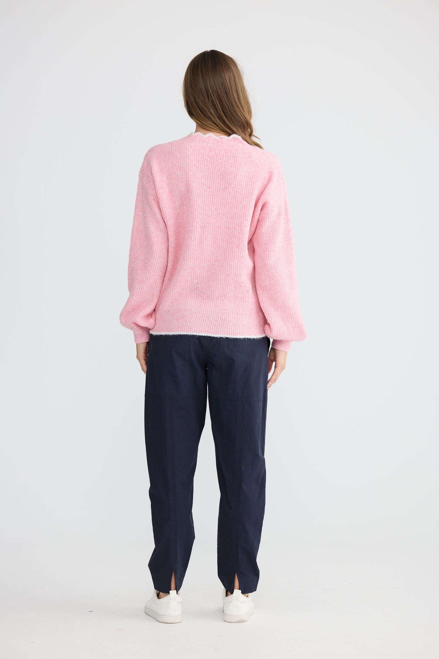 Model wearing Ocean Knit Pink with scalloped V-neckline, alternate view on white background