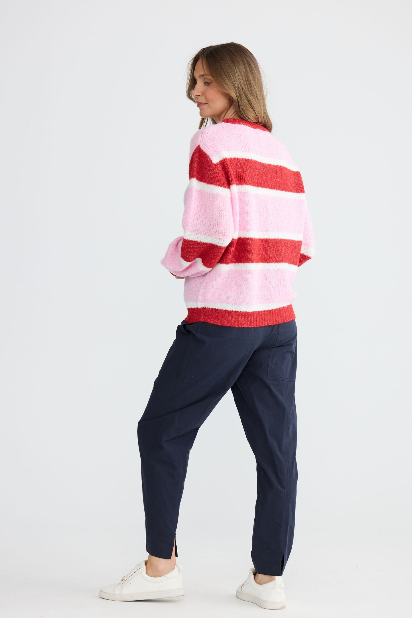 Model wearing Cove Knit Pink Multi Stripe with multi stripe knit finish, full-length view on white background