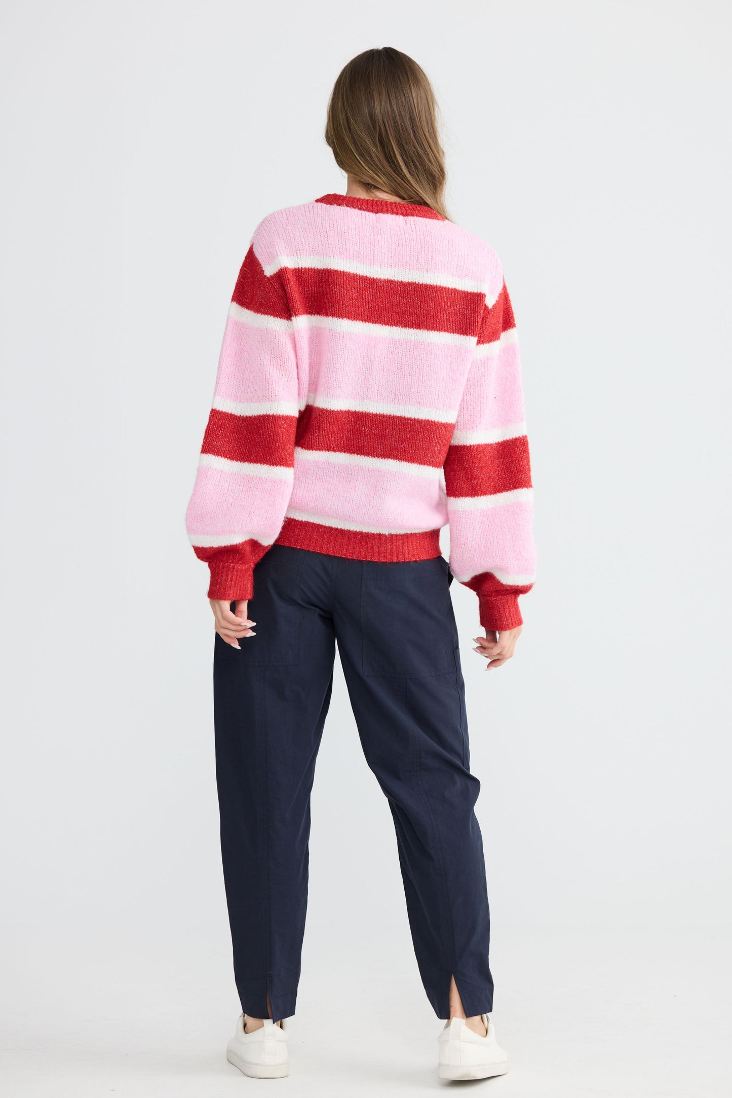 Model wearing Cove Knit Pink Multi Stripe with multi stripe knit finish, front view on white background