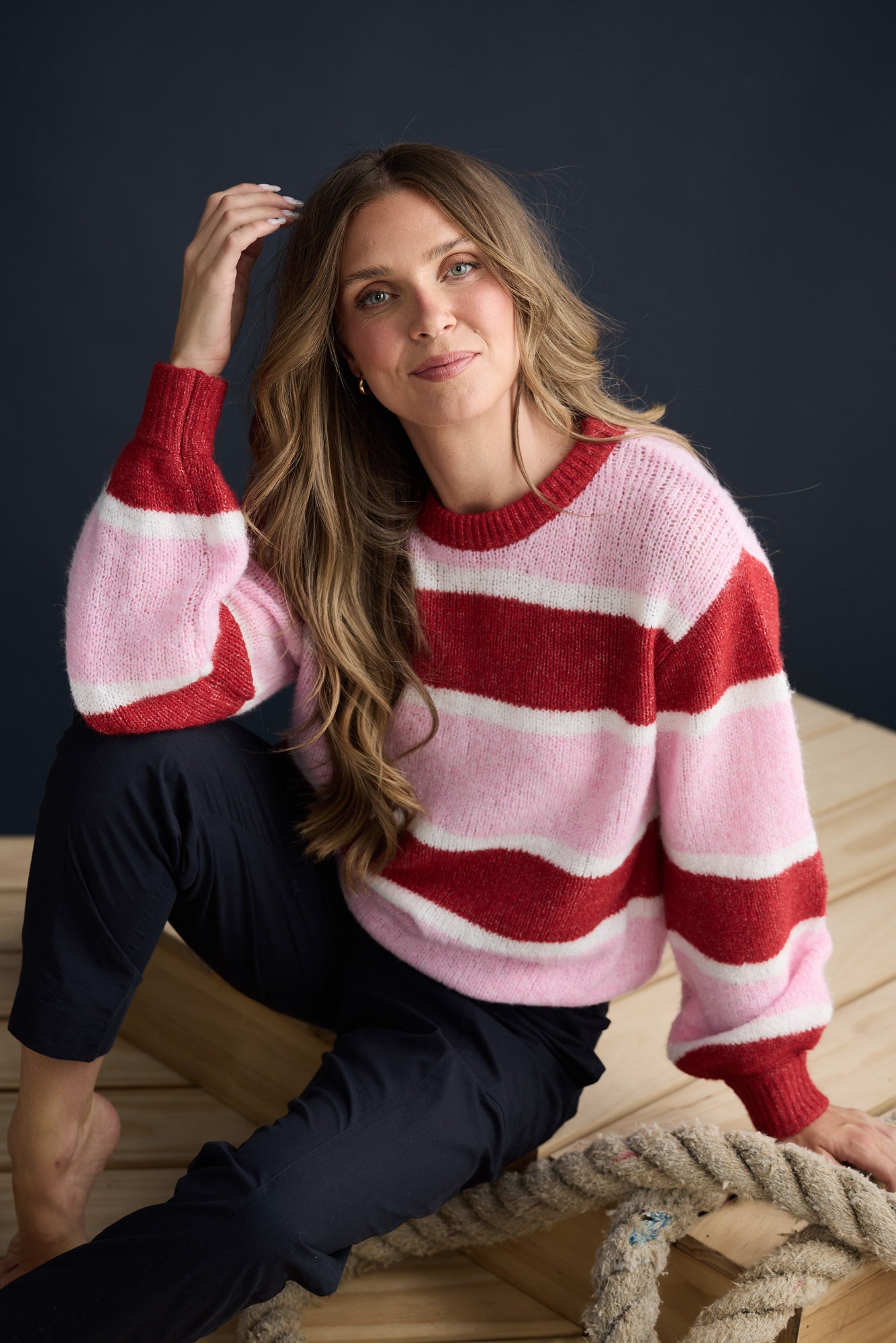 Model wearing Cove Knit Pink Multi Stripe with multi stripe knit finish, campaign lifestyle view