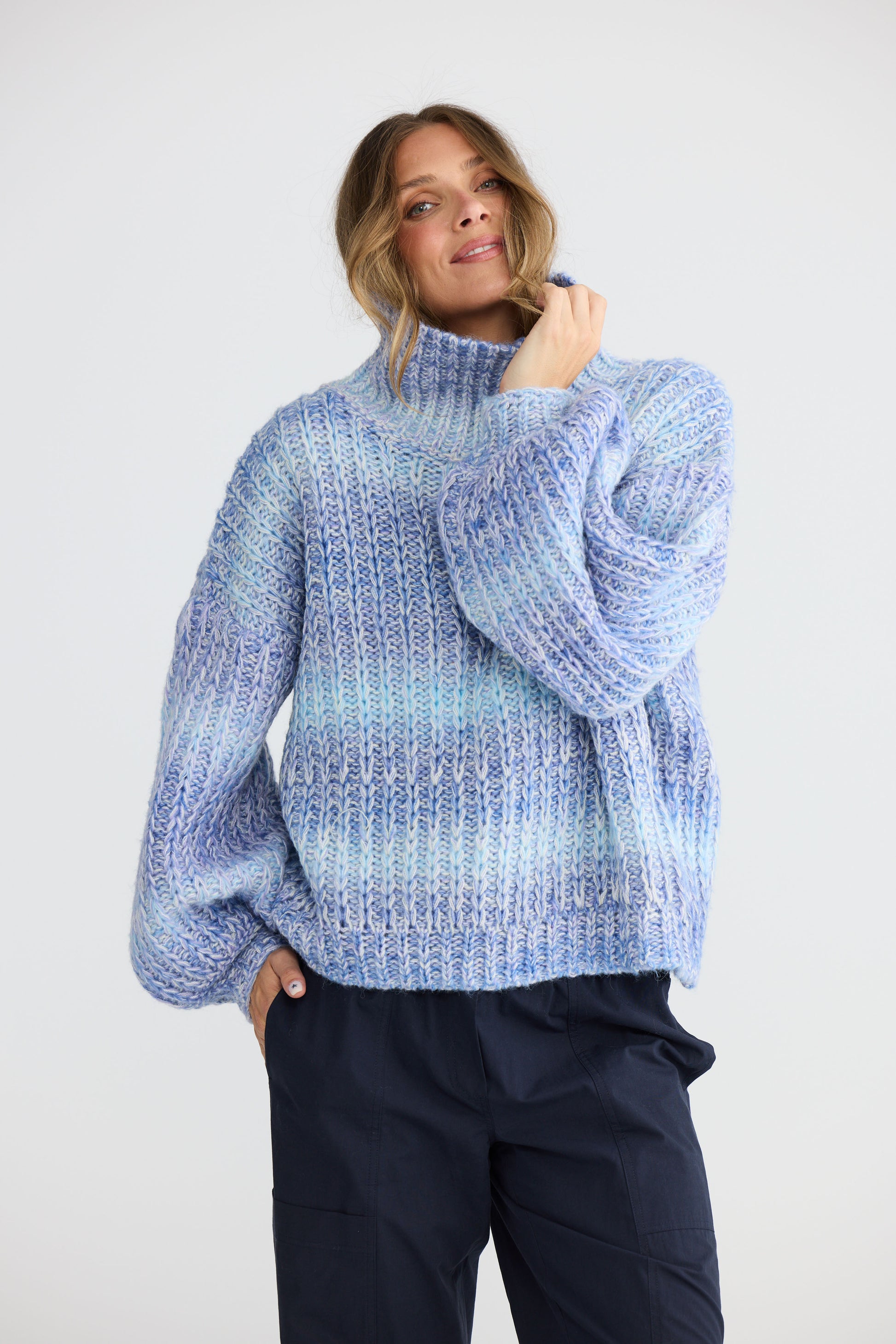 Model wearing Olas Knit Blue Ombre with chunky high neckline, back view on white background