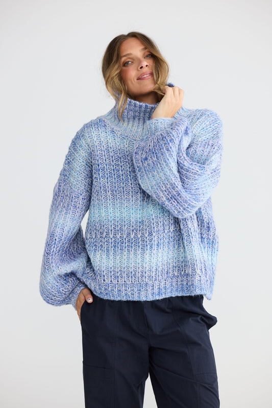 Model wearing Olas Knit Blue Ombre with chunky high neckline, back view on white background