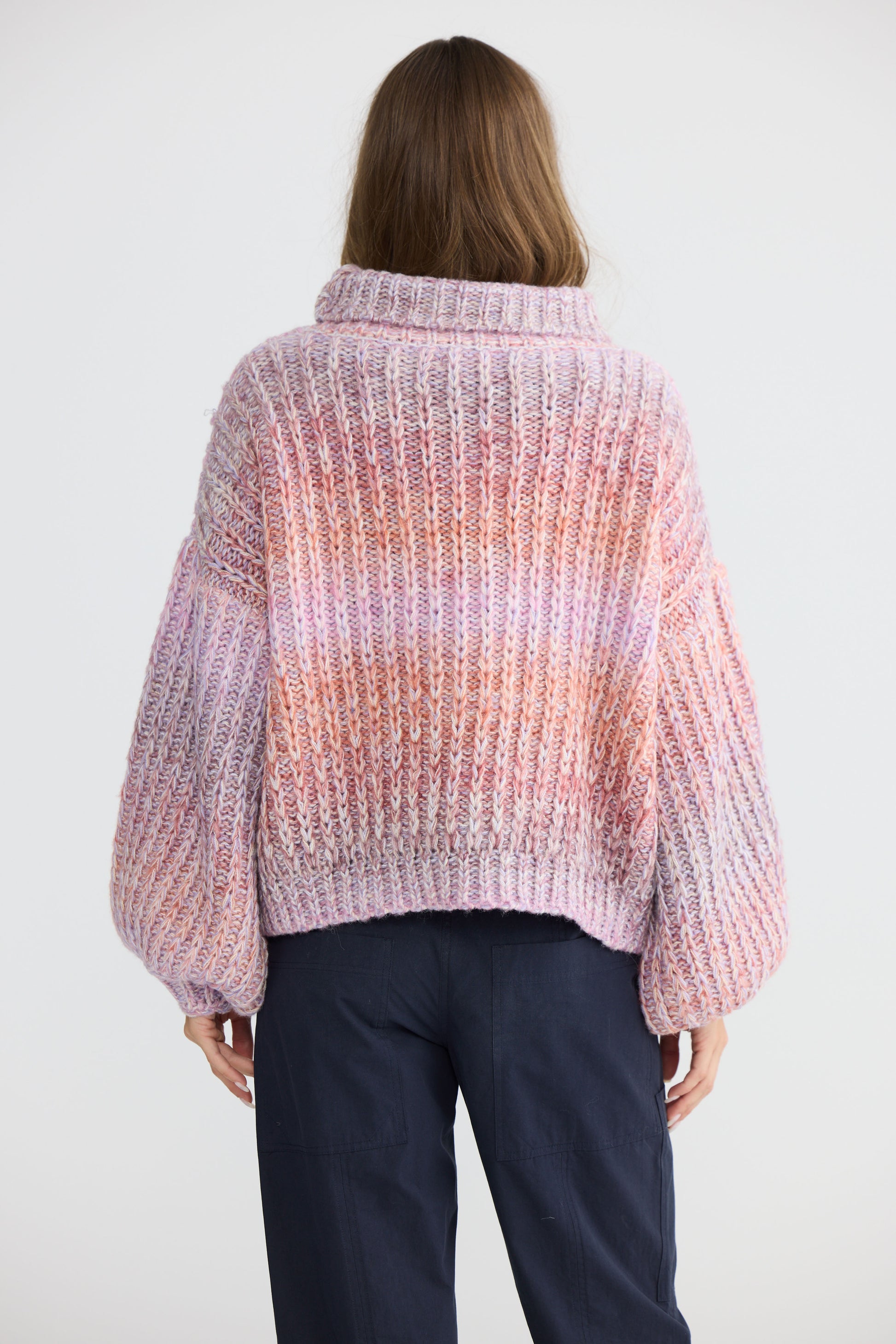 Model wearing Olas Knit Pink Ombre with chunky high neckline, back view on white background