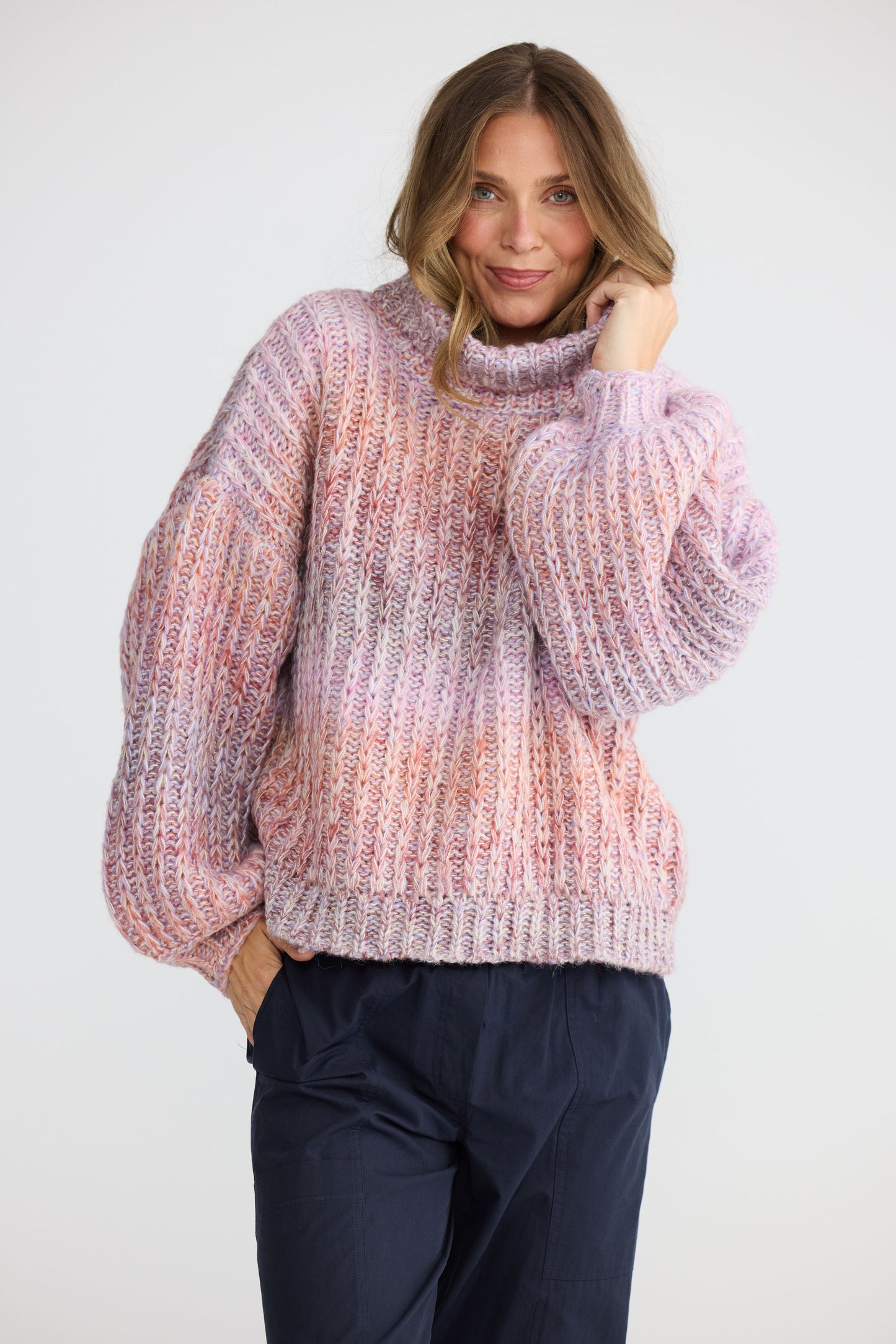 Model wearing Olas Knit Pink Ombre with chunky high neckline, full-length view on white background