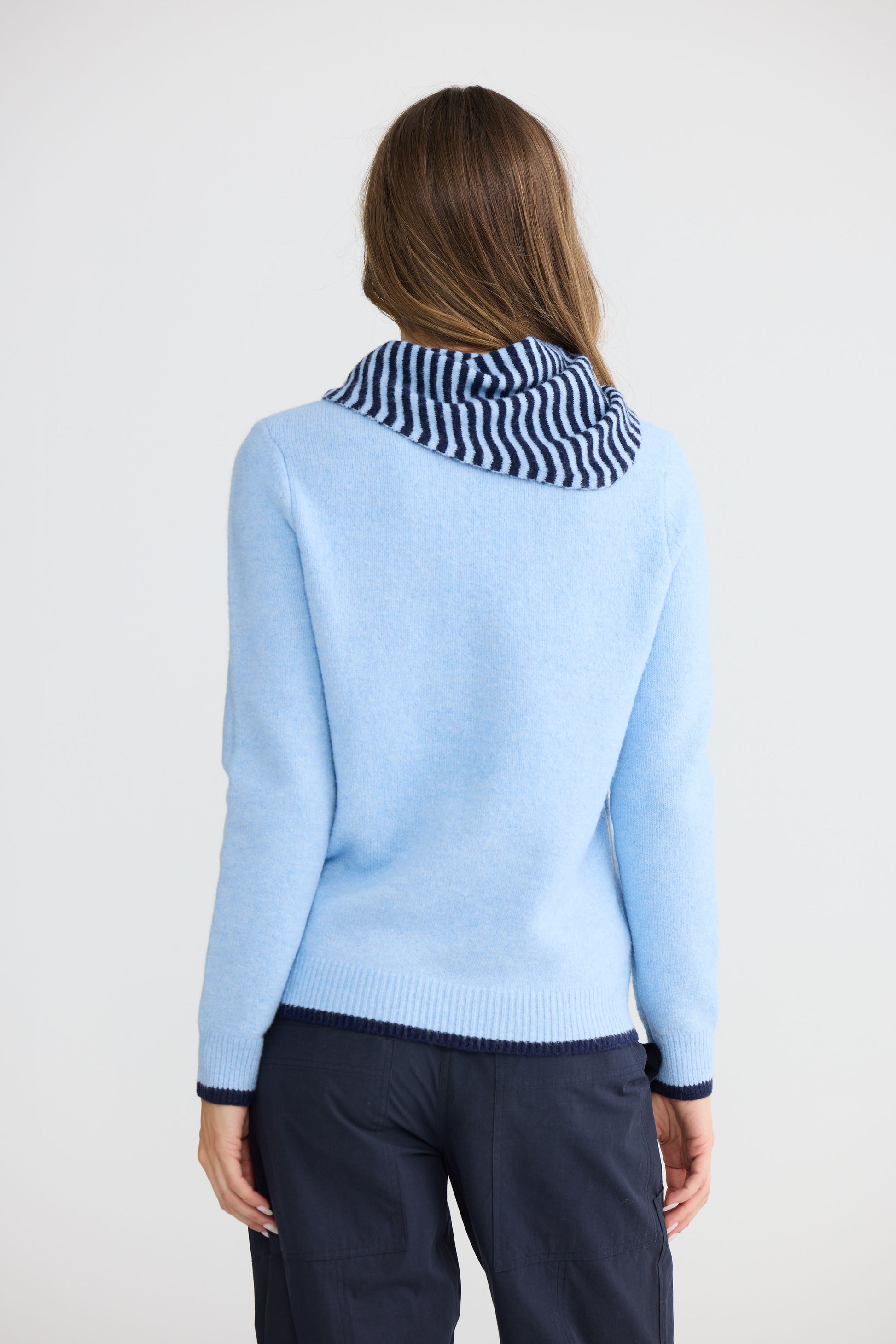Model wearing Sabbia Knit Blue Multi with contrast tipping and triangle scarf, studio detail view on white background