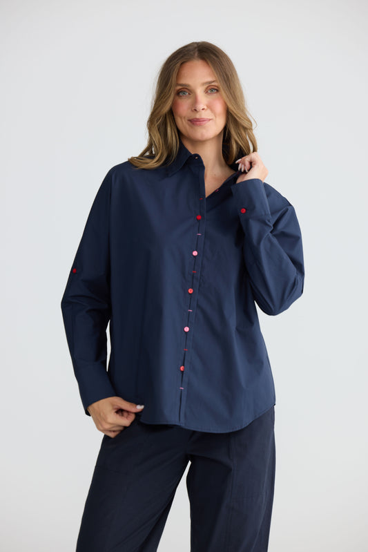 Model wearing Fae Shirt Navy with contrast buttons and stitching, front view on white background