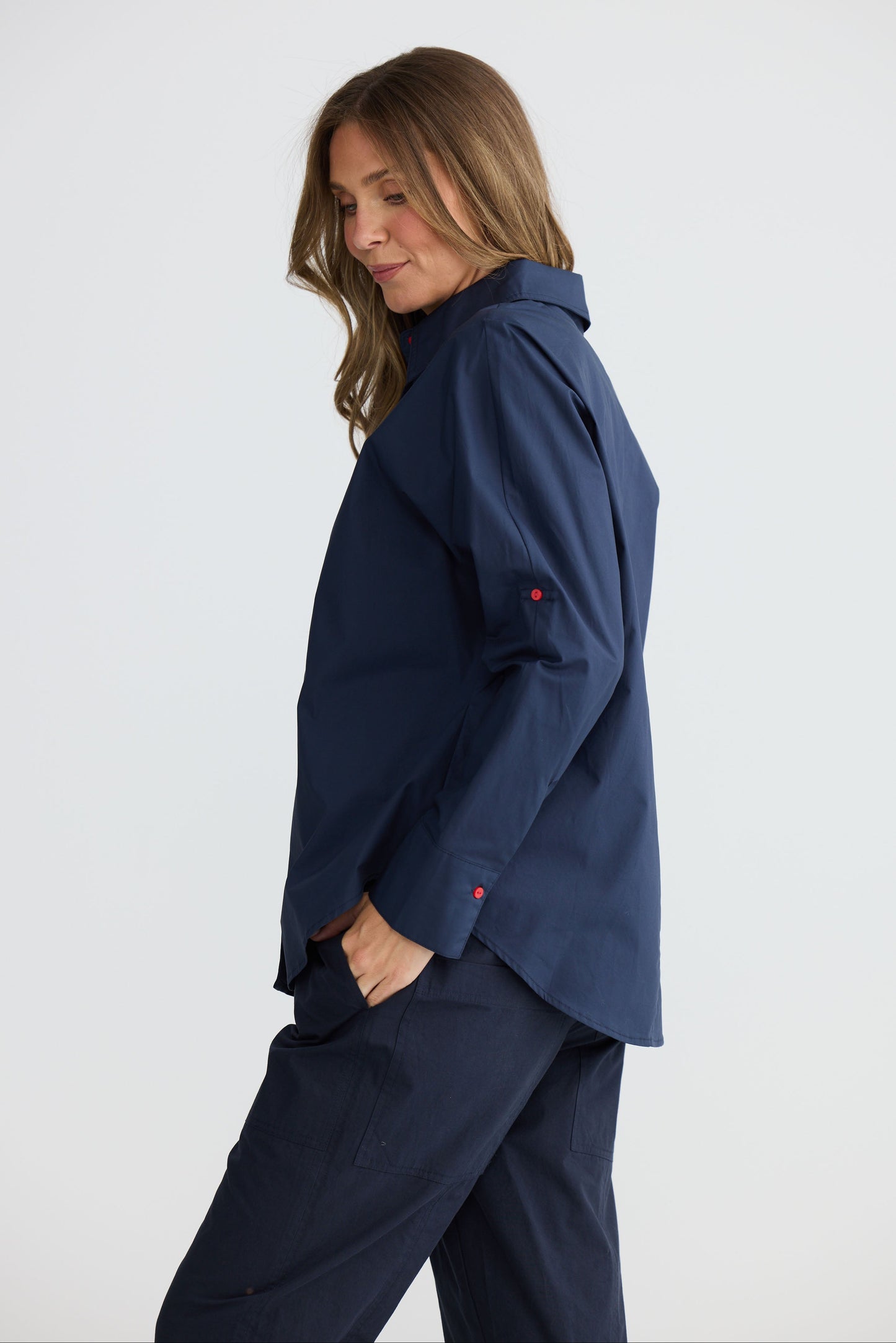 Model wearing Fae Shirt Navy with contrast buttons and stitching, back view on white background
