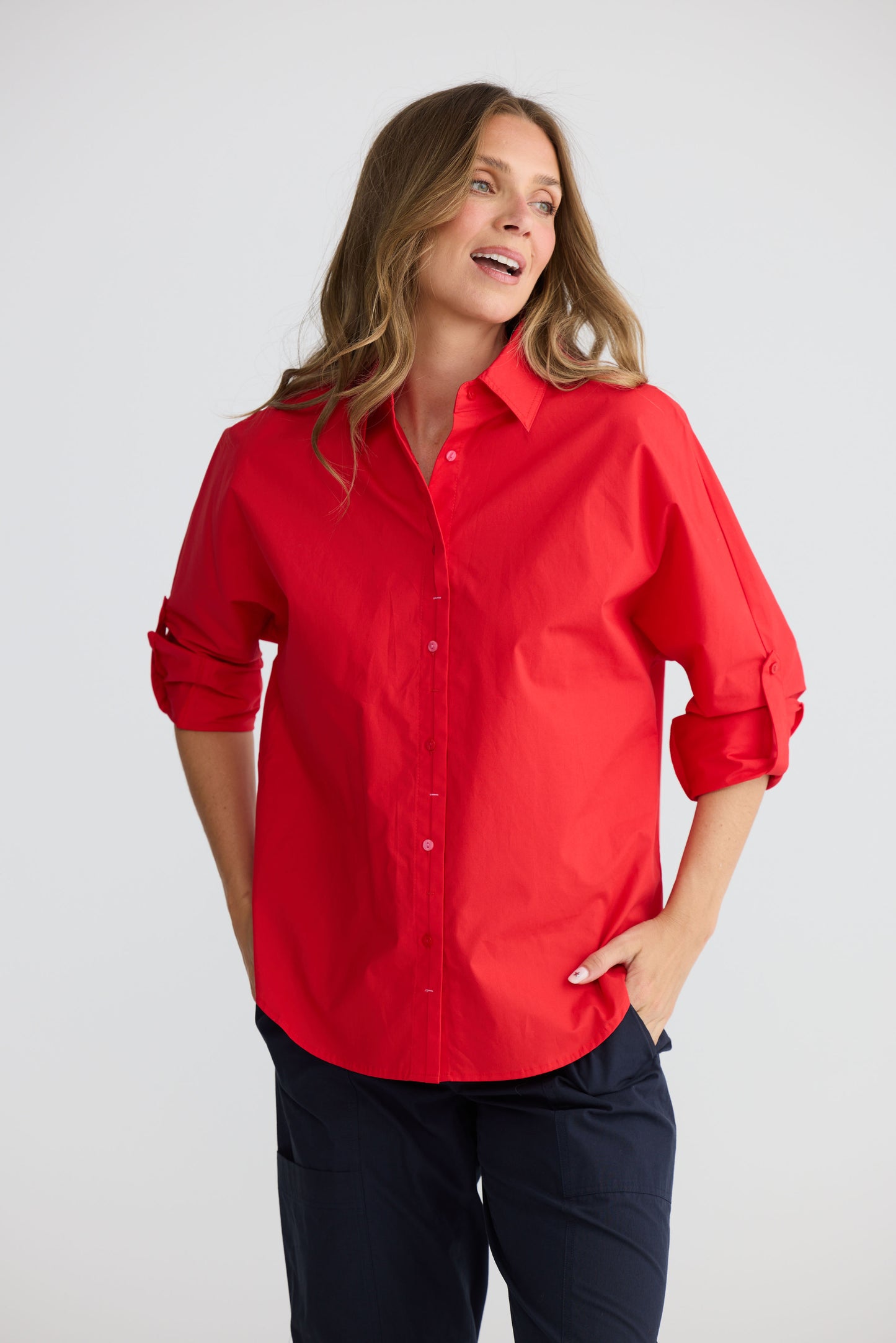 Model wearing Fae Shirt Red with contrast buttons and stitching, full-length view on white background