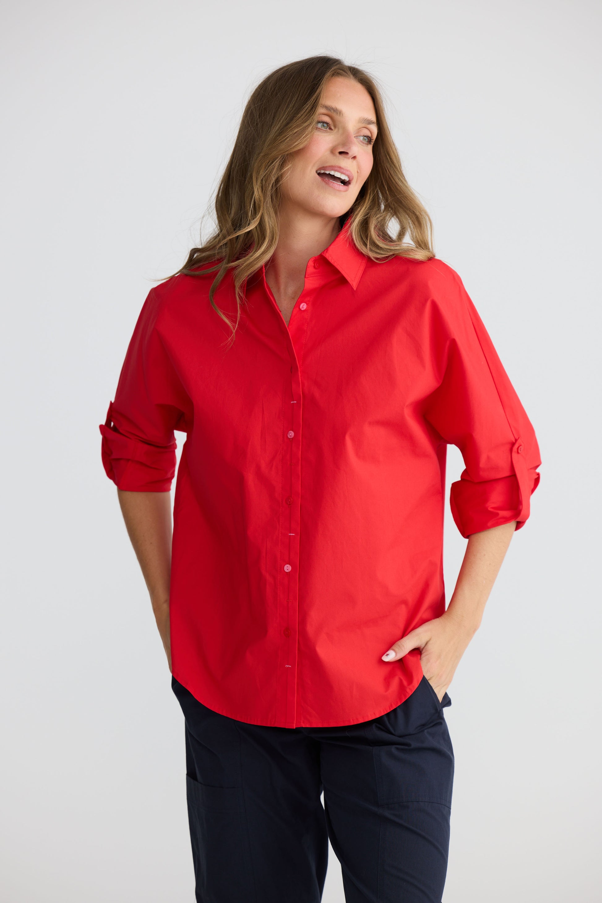 Model wearing Fae Shirt Red with contrast buttons and stitching, full-length view on white background