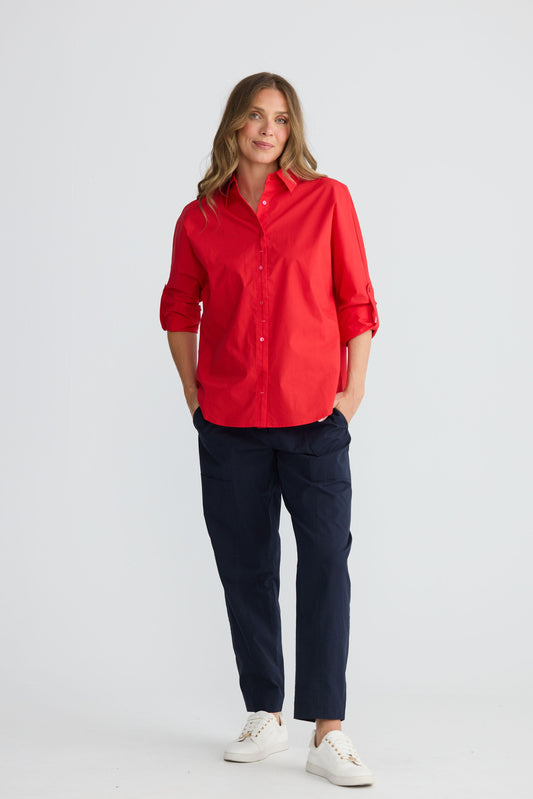 Model wearing Fae Shirt Red with contrast buttons and stitching, front view on white background