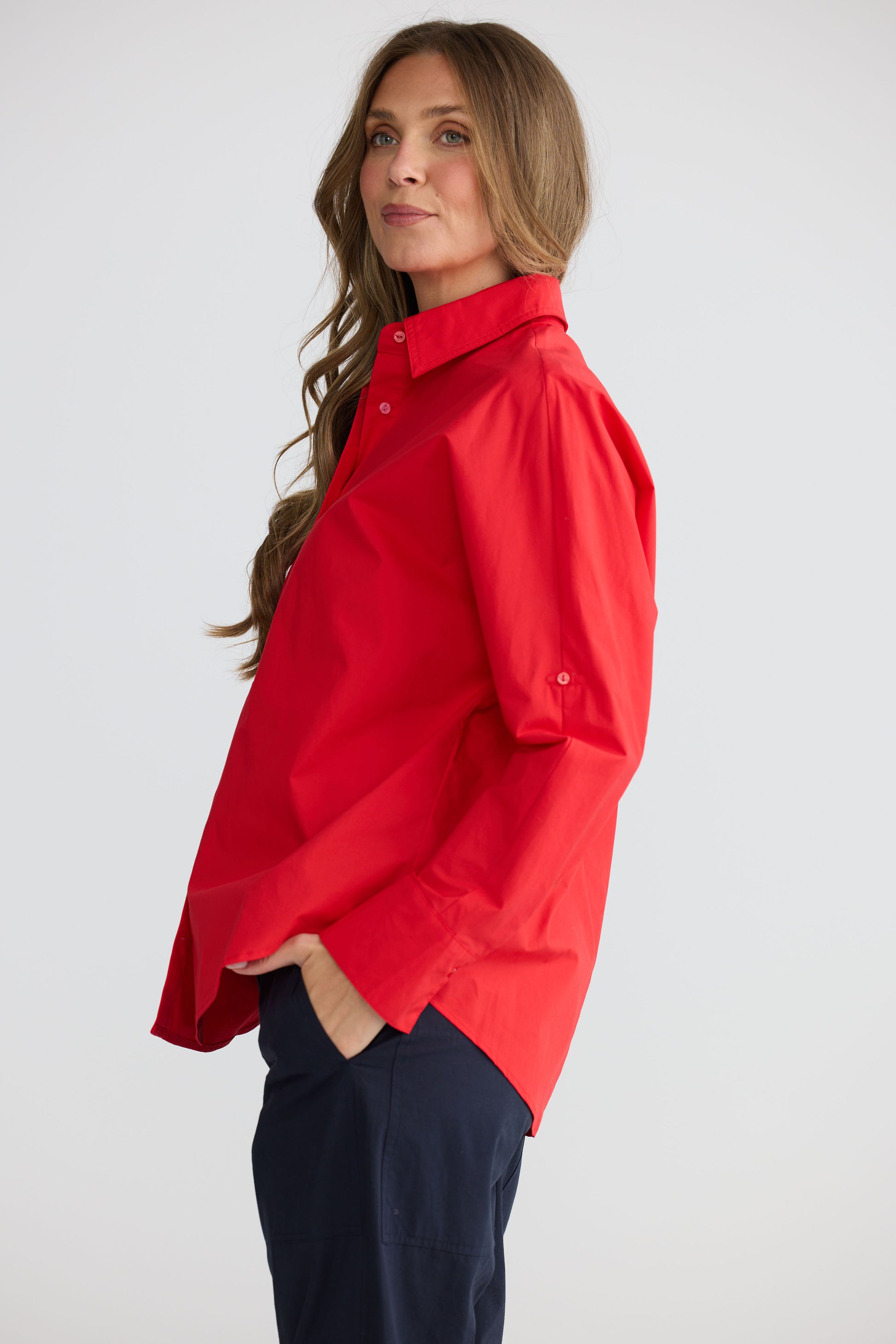 Model wearing Fae Shirt Red with contrast buttons and stitching, alternate view on white background