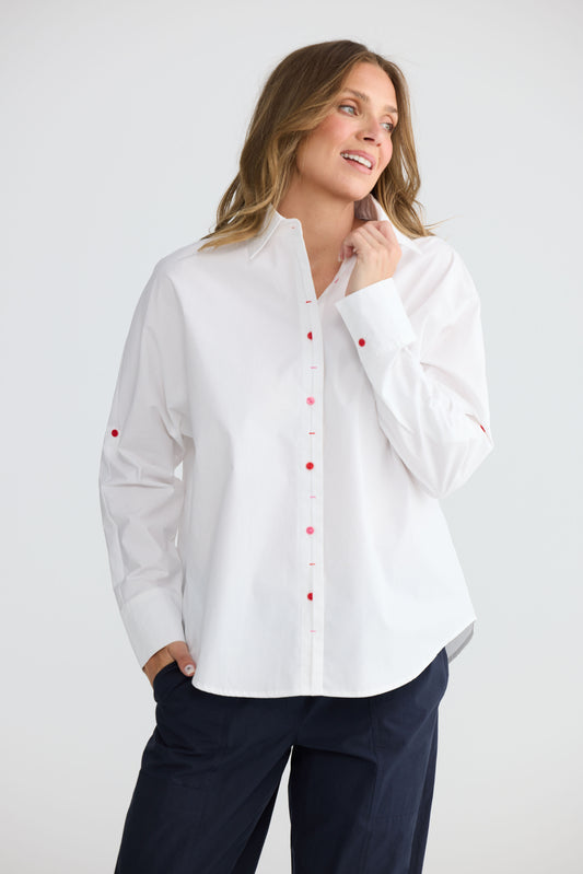 Model wearing Fae Shirt White with contrast buttons and stitching, side view on white background