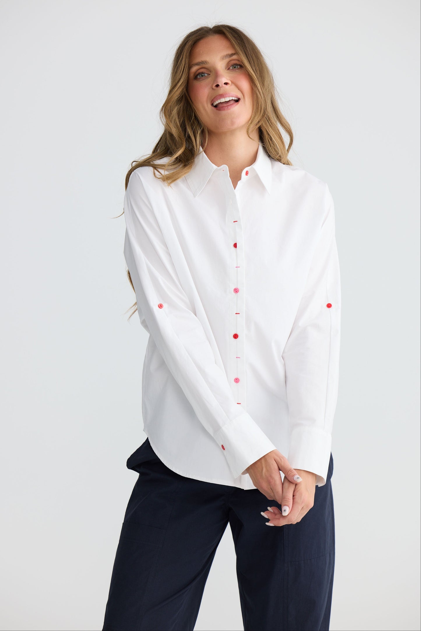 Model wearing Fae Shirt White with contrast buttons and stitching, detail view on white background