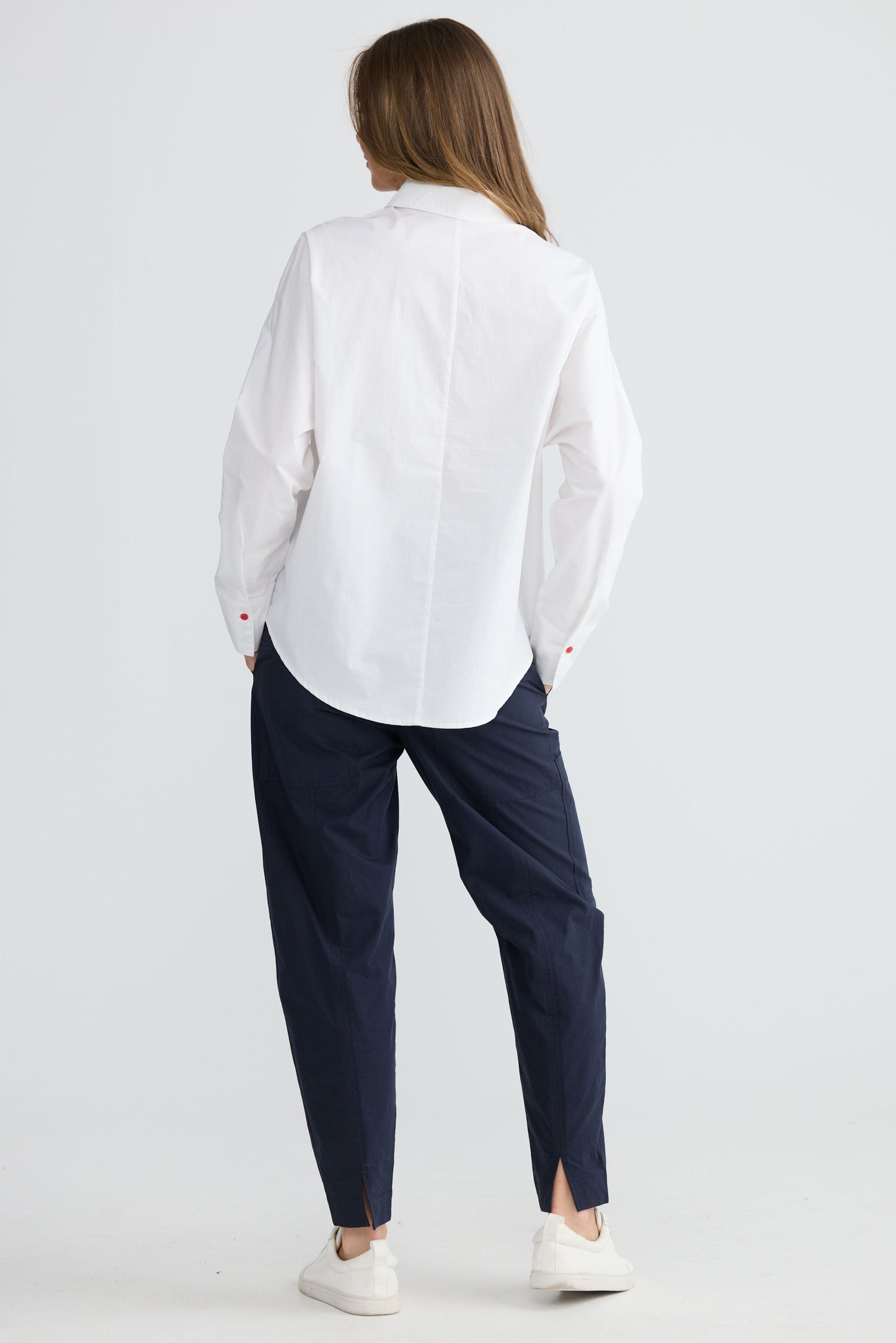 Model wearing Fae Shirt White with contrast buttons and stitching, back view on white background