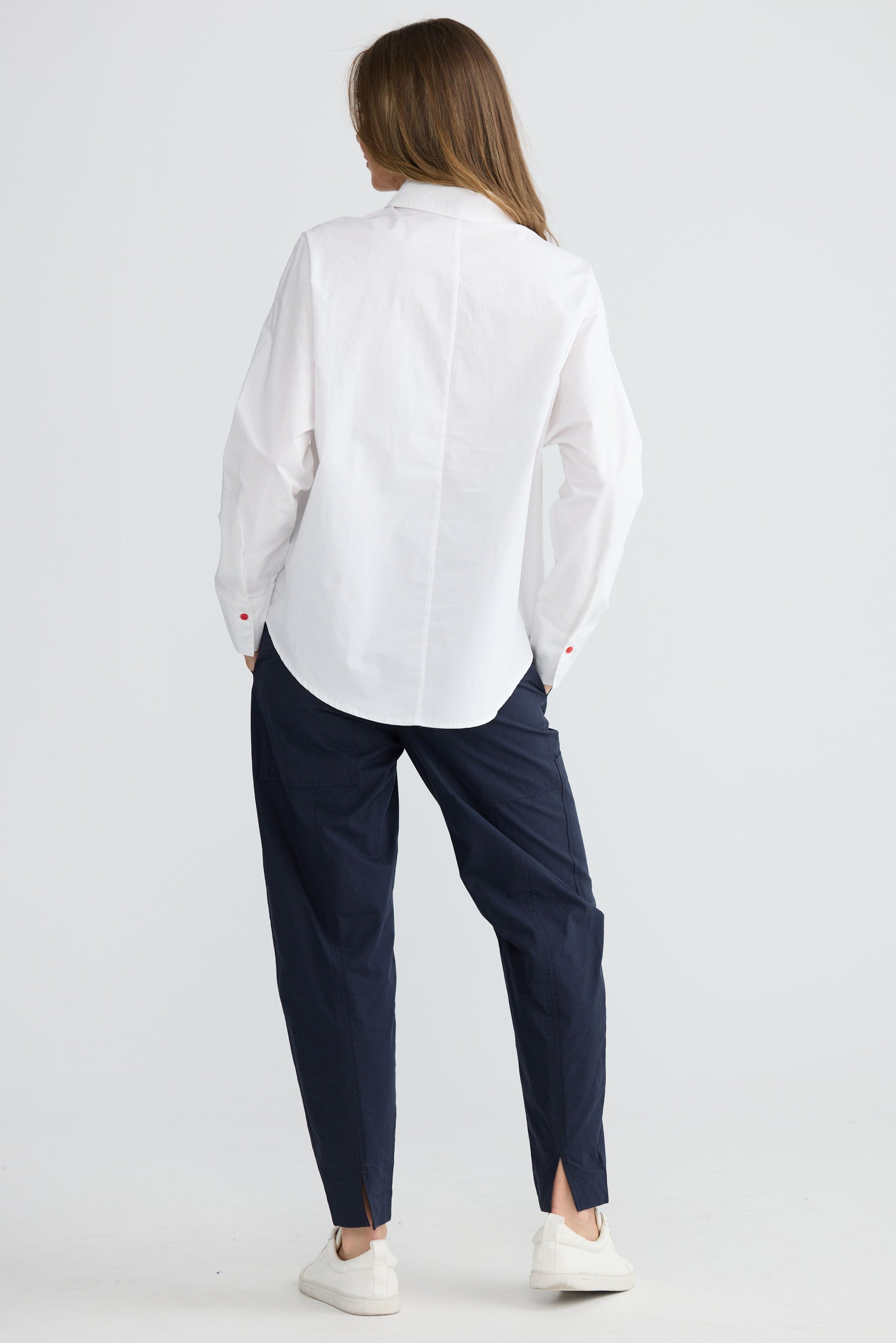 Model wearing Fae Shirt White with contrast buttons and stitching, back view on white background