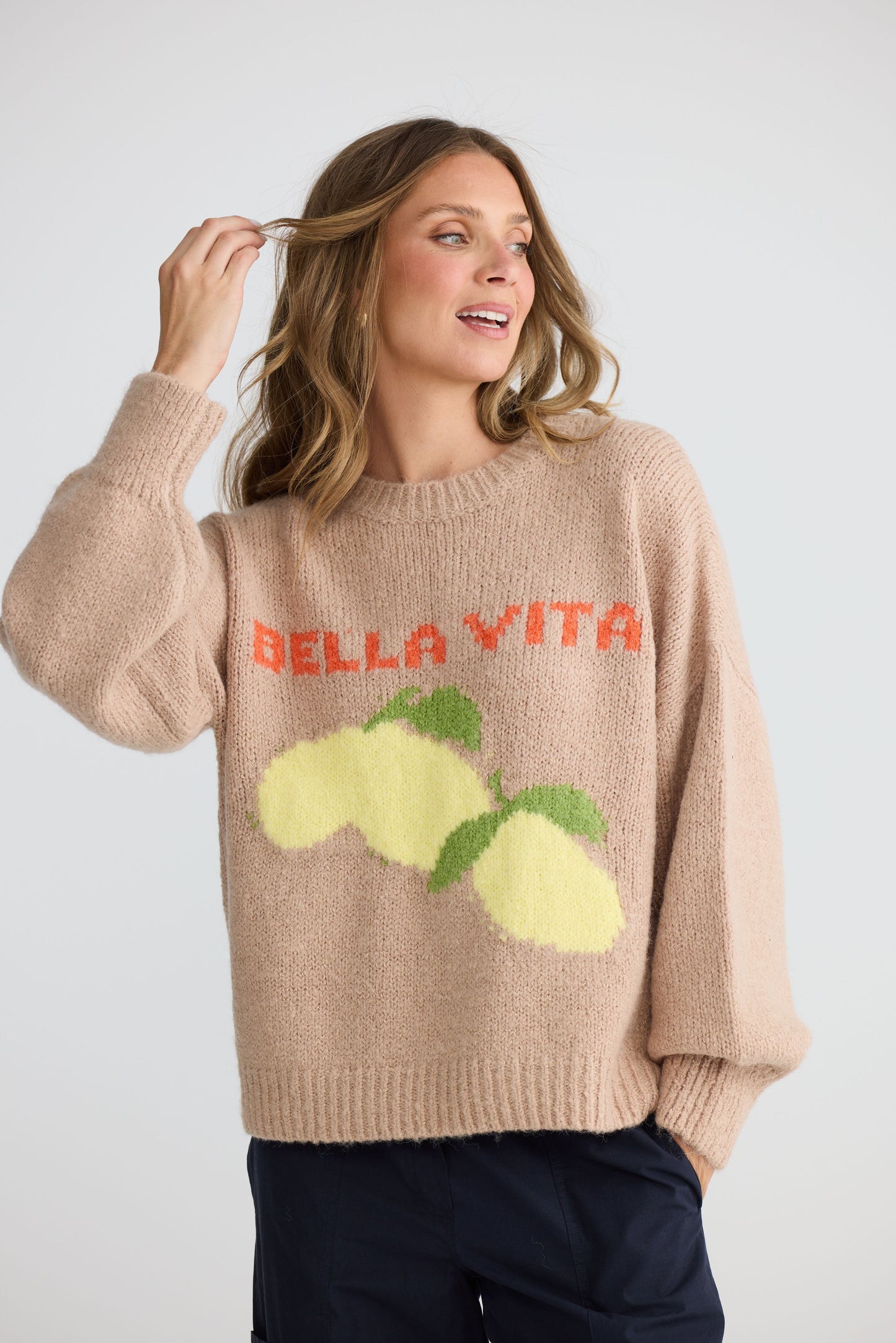 Model wearing Bella Vita Knit Oatmeal with oversized relaxed fit, back view on white background