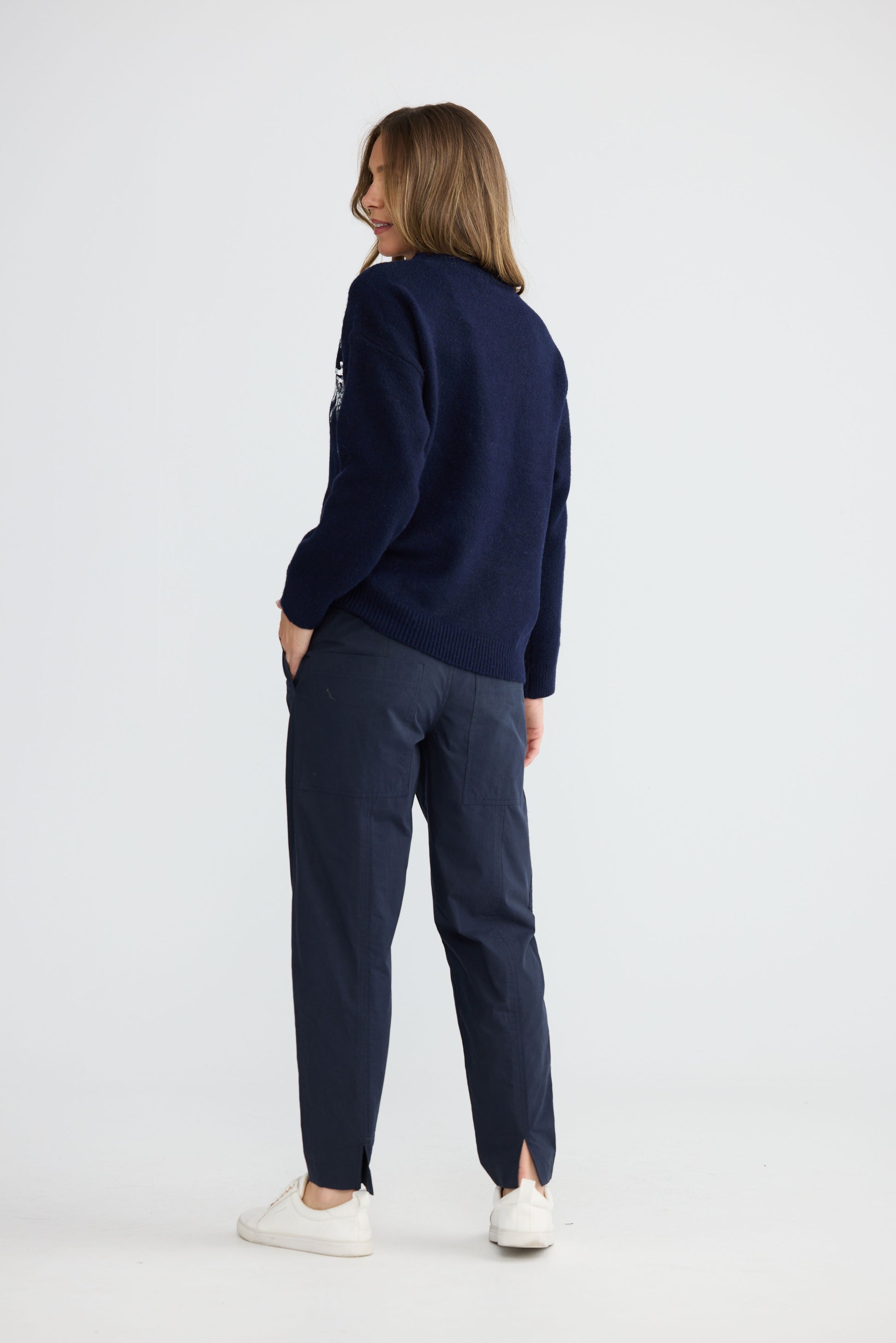 Model wearing Paradise Knit Navy with dropped shoulder and relaxed fit, side view on white background