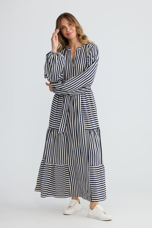 Model wearing Marla Dress Navy and White Stripe with balloon sleeves and waist tie, alternate view on white background