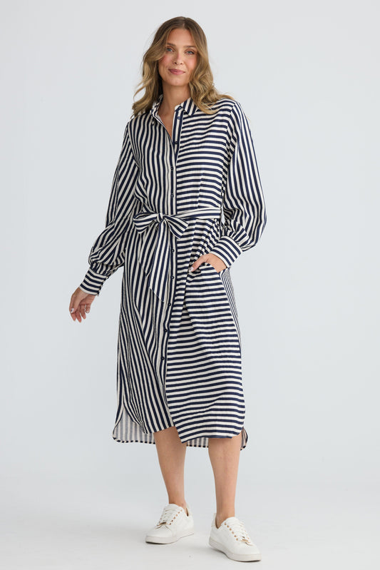 Model wearing Carnation Shirt Dress Navy and White Stripe with waist tie and in-seam pockets, alternate view on white background