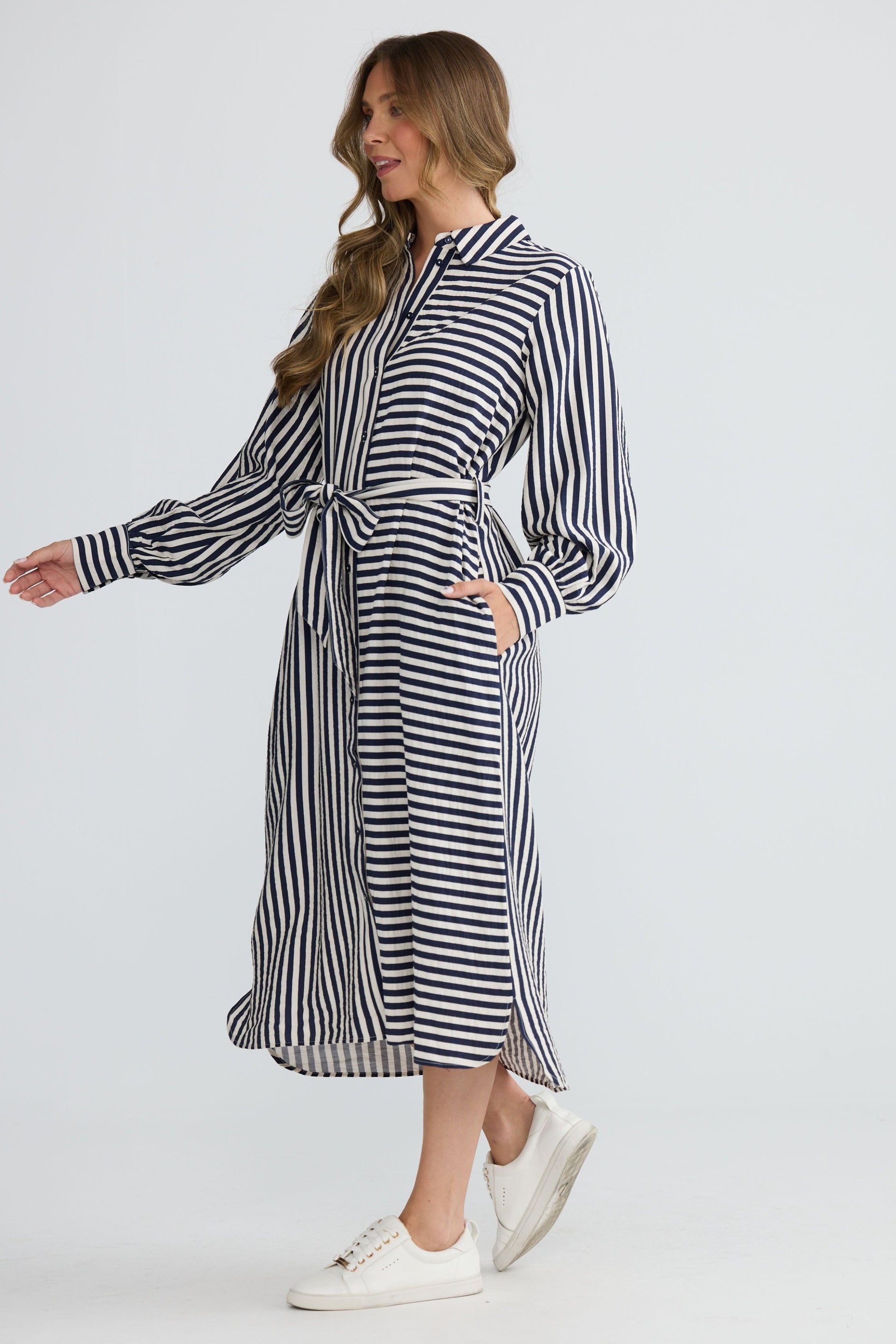 Model wearing Carnation Shirt Dress Navy and White Stripe with waist tie and in-seam pockets, back view on white background