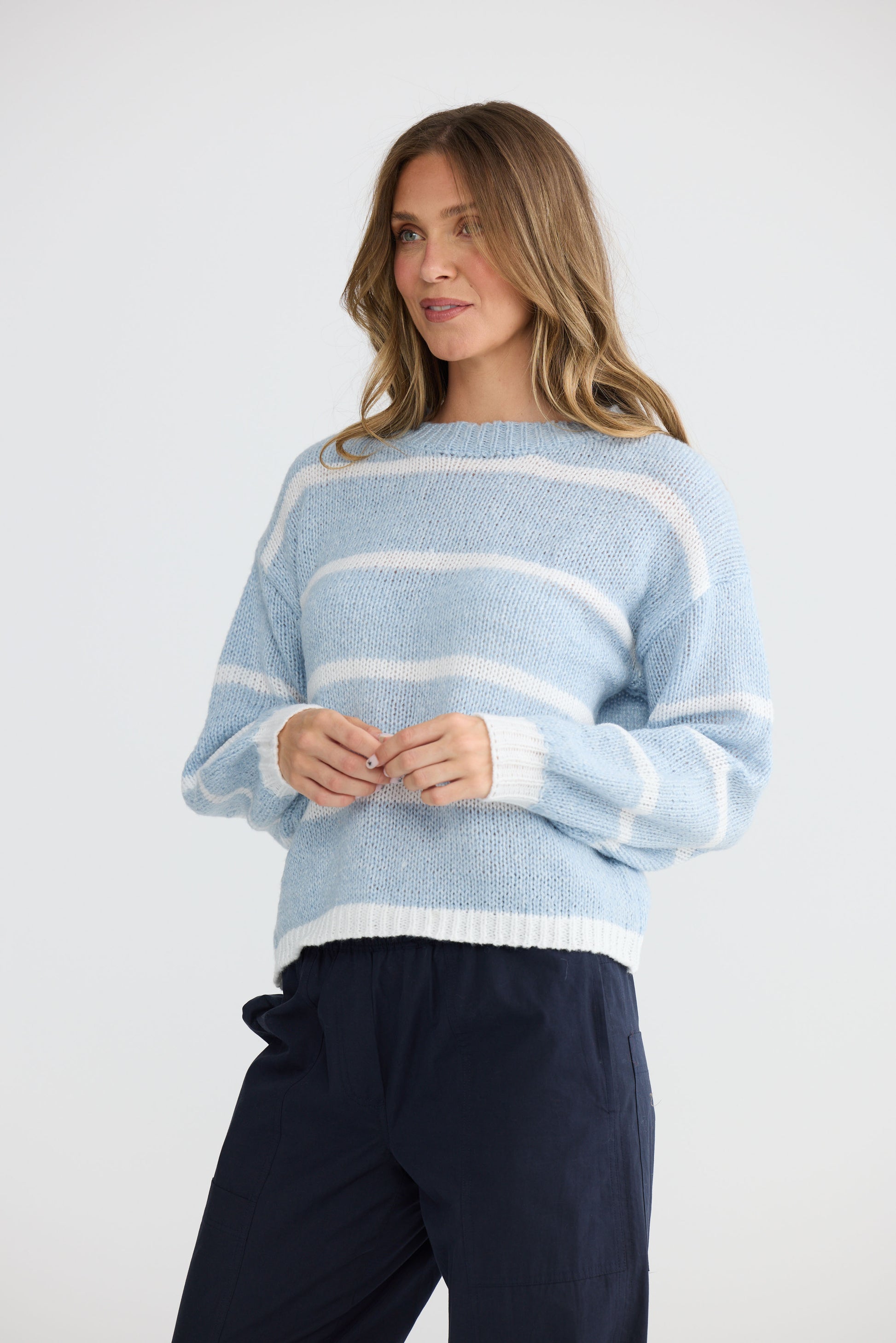 Model wearing Bay Knit Blue Stripe with ribbed trims and relaxed fit, front view on white background