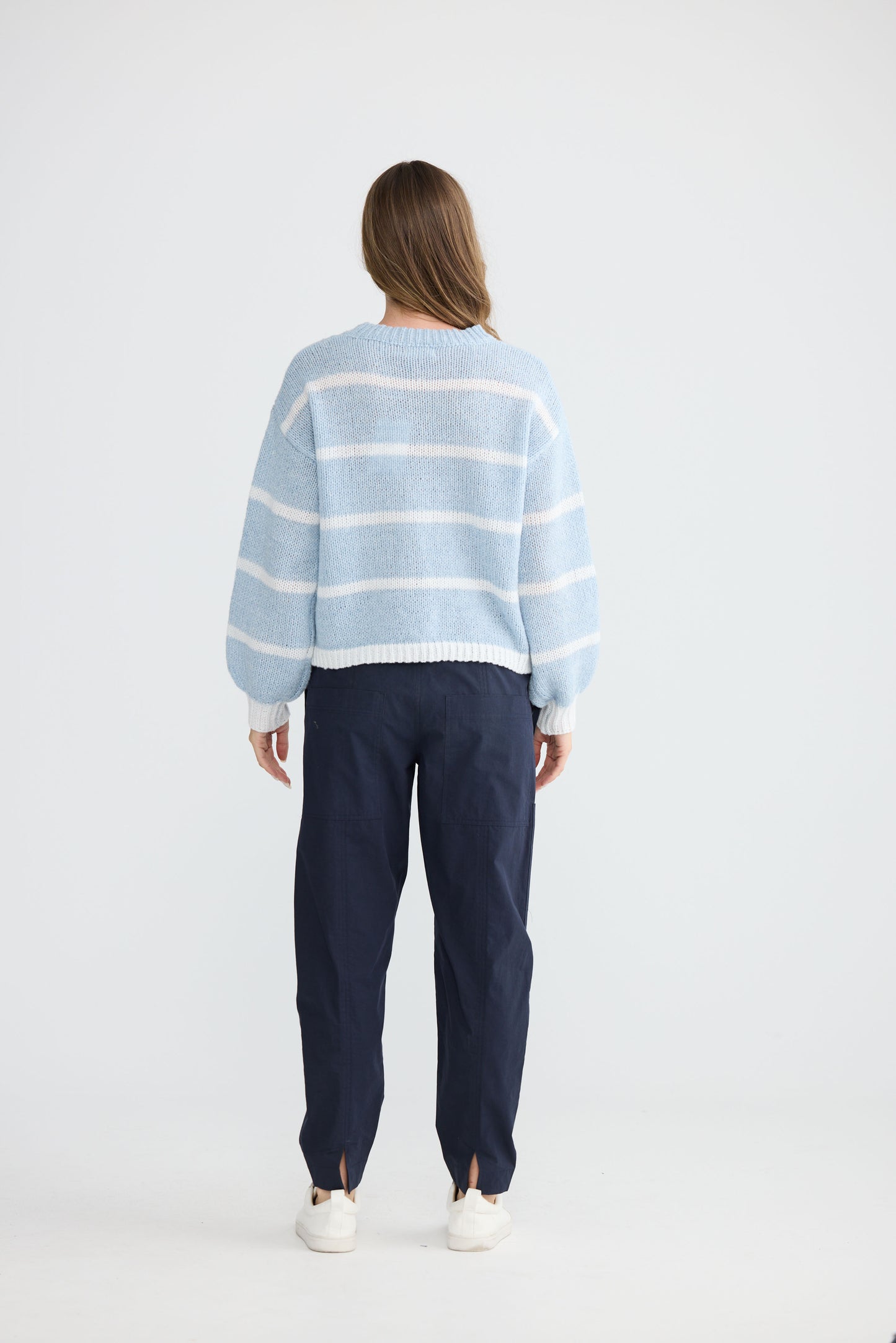 Model wearing Bay Knit Blue Stripe with ribbed trims and relaxed fit, detail view on white background