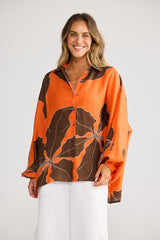 Model wearing Cliffside Shirt in hibiscus breeze, front view. Oversized, button front, balloon sleeve, large leaf print.