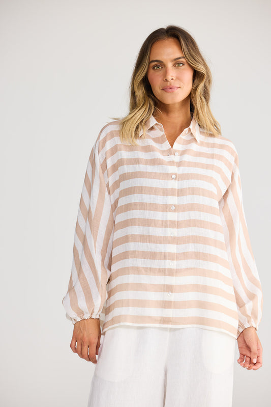 Model wearing Cliffside Shirt in natural with white, front view. Oversized button front, balloon sleeve, tan/white stripe.