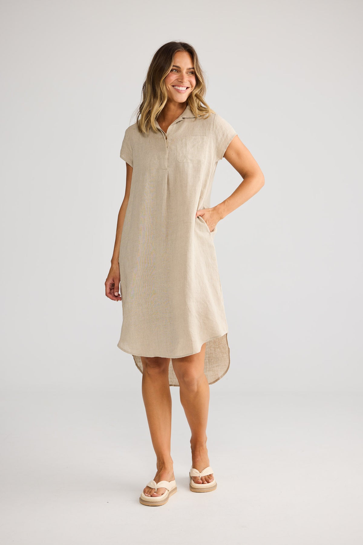 Model wearing Ahoy Tunic in natural linen, front view. Collared, hi-lo hem, cap sleeve, front patch pocket.