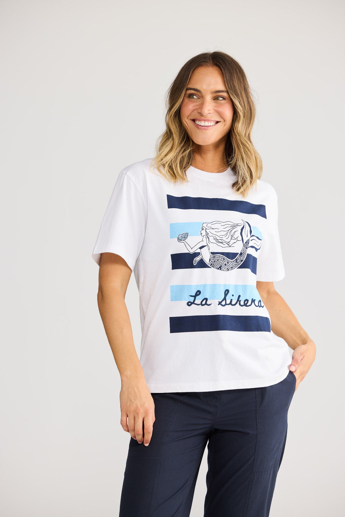 Model wearing Coral Tee in white, front view. Round neck, short sleeve, lobster graphic motif at chest.