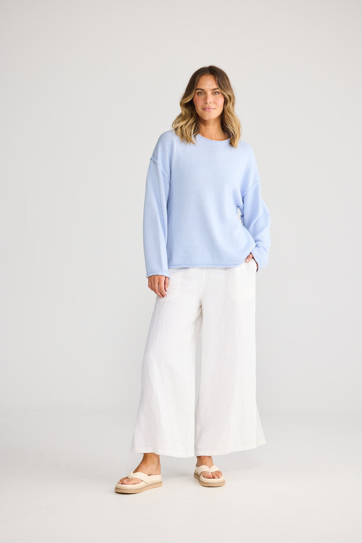 Model wearing Breaker Knit in blue, front view. Relaxed crew neck knit with rolled cuffs.