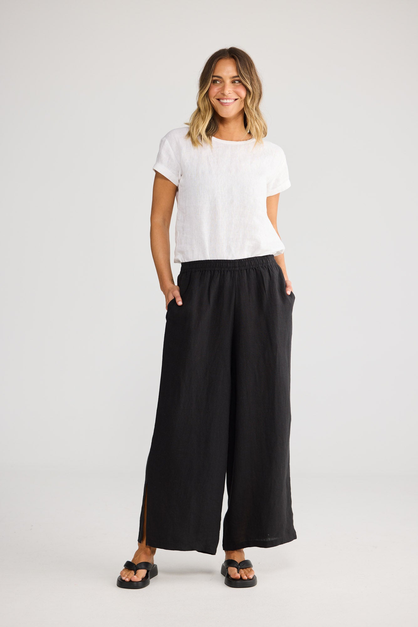 Model wearing Fly Away Pant in black, front view. Relaxed wide leg, elasticated waistband.
