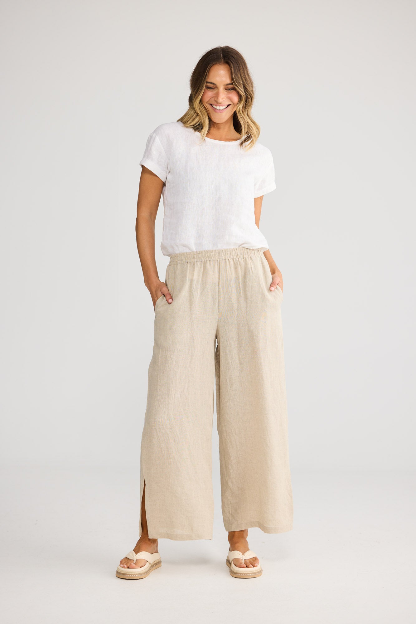 Model wearing Fly Away Pant in natural linen, front view. Relaxed wide leg, elasticated waistband.