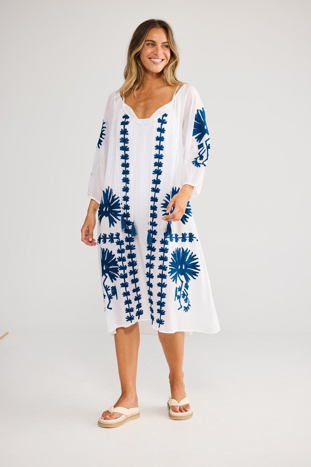 Aloha Dress in White with a sleeveless silhouette with a gathered V-neckline and ruffle bust seam.