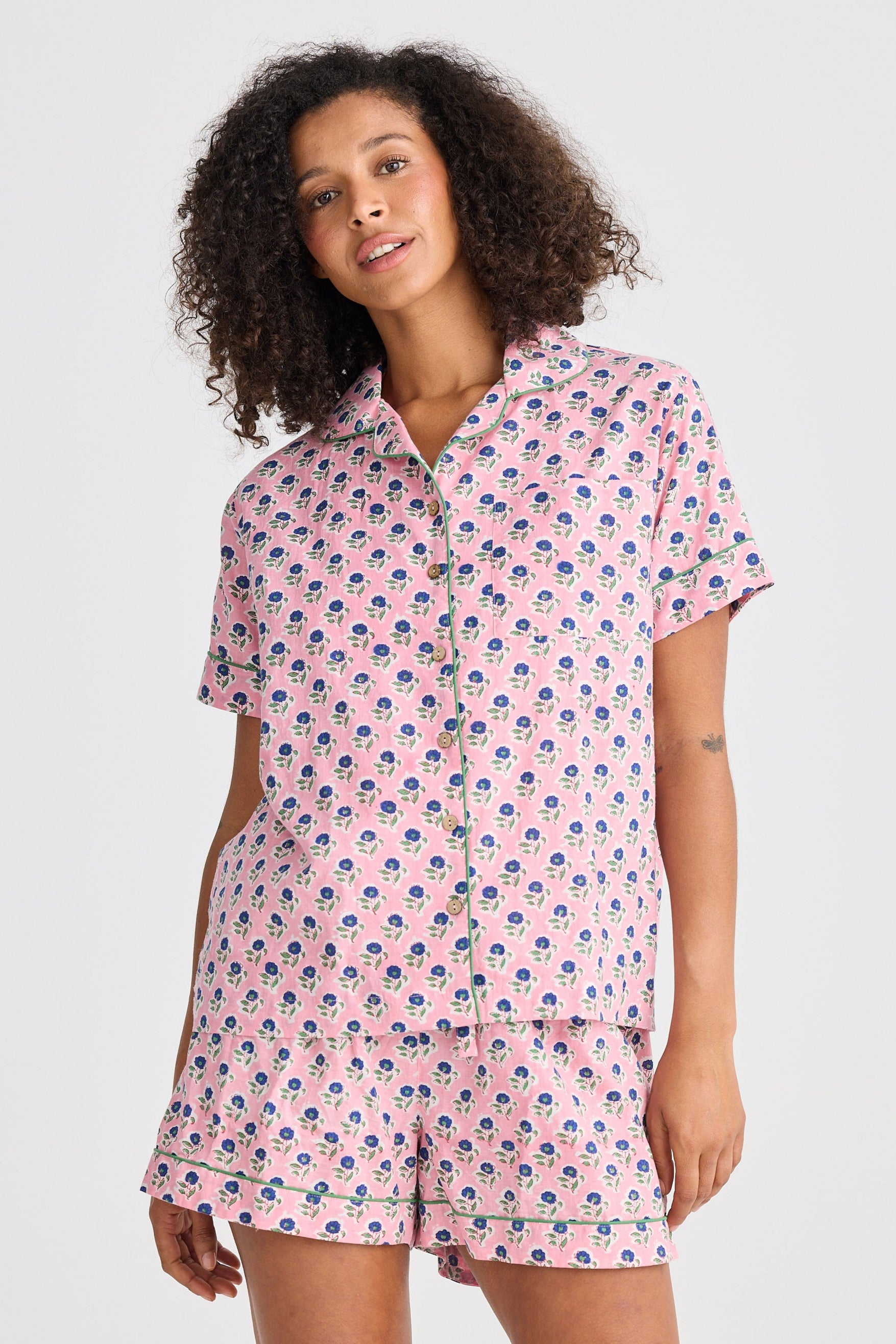 Woman wearing a pink floral pajama set on a white background