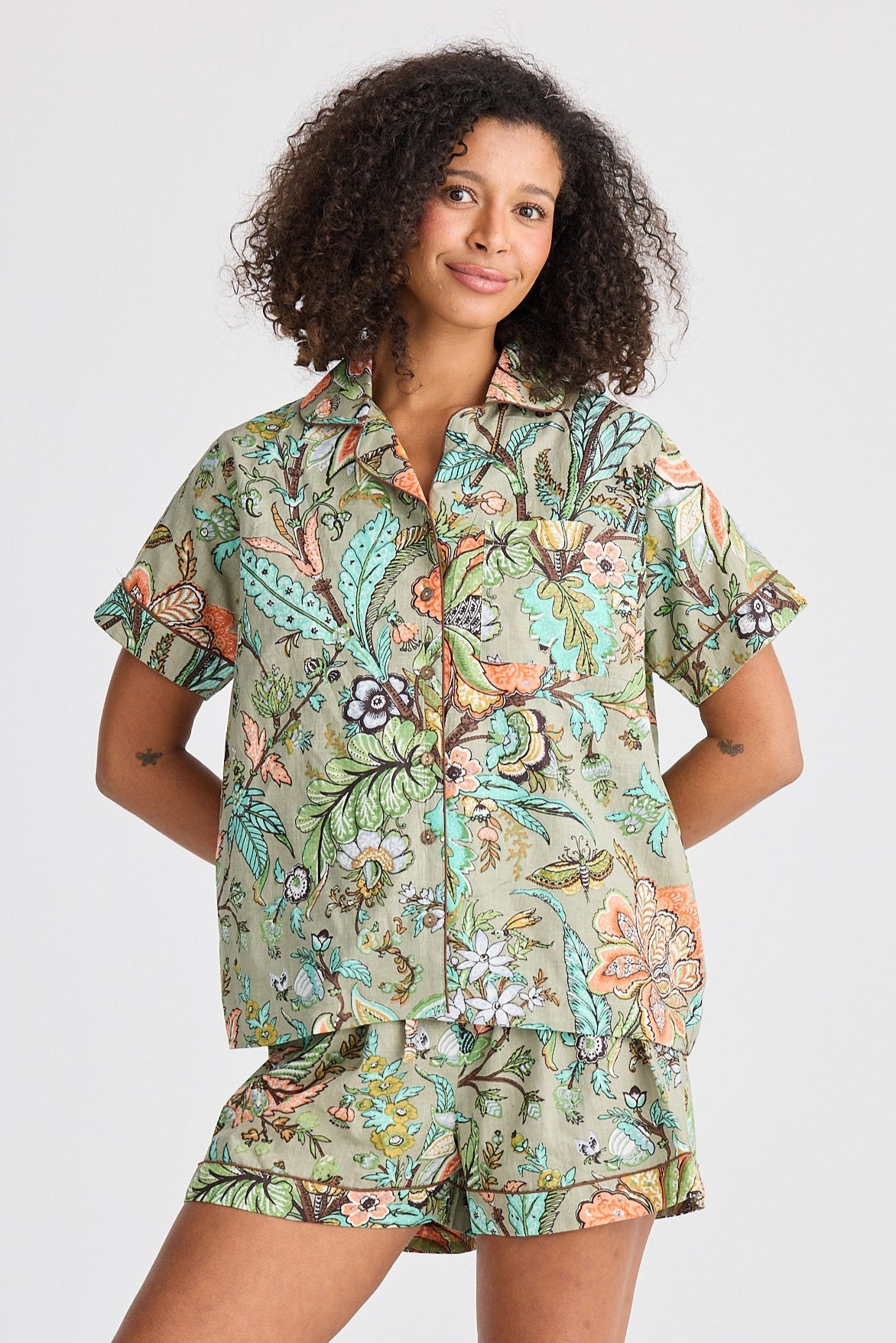 Woman wearing a floral pajama set on a white background