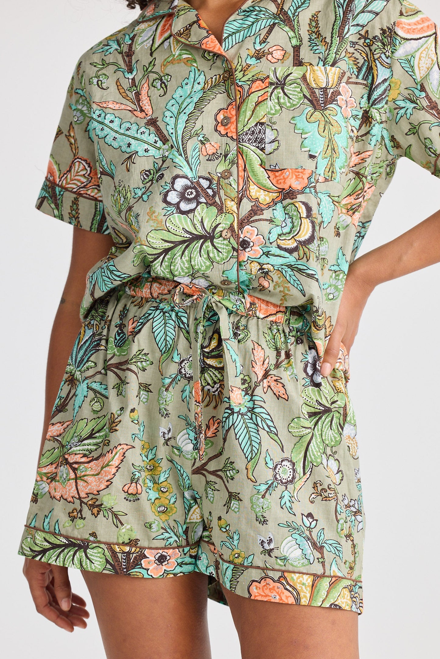 Person wearing a floral patterned pyjama set on a white background