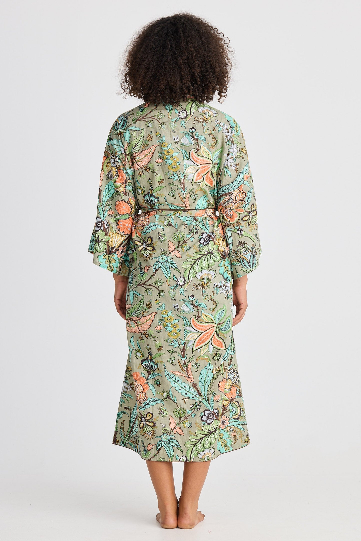Woman wearing a floral patterned robe on a white background