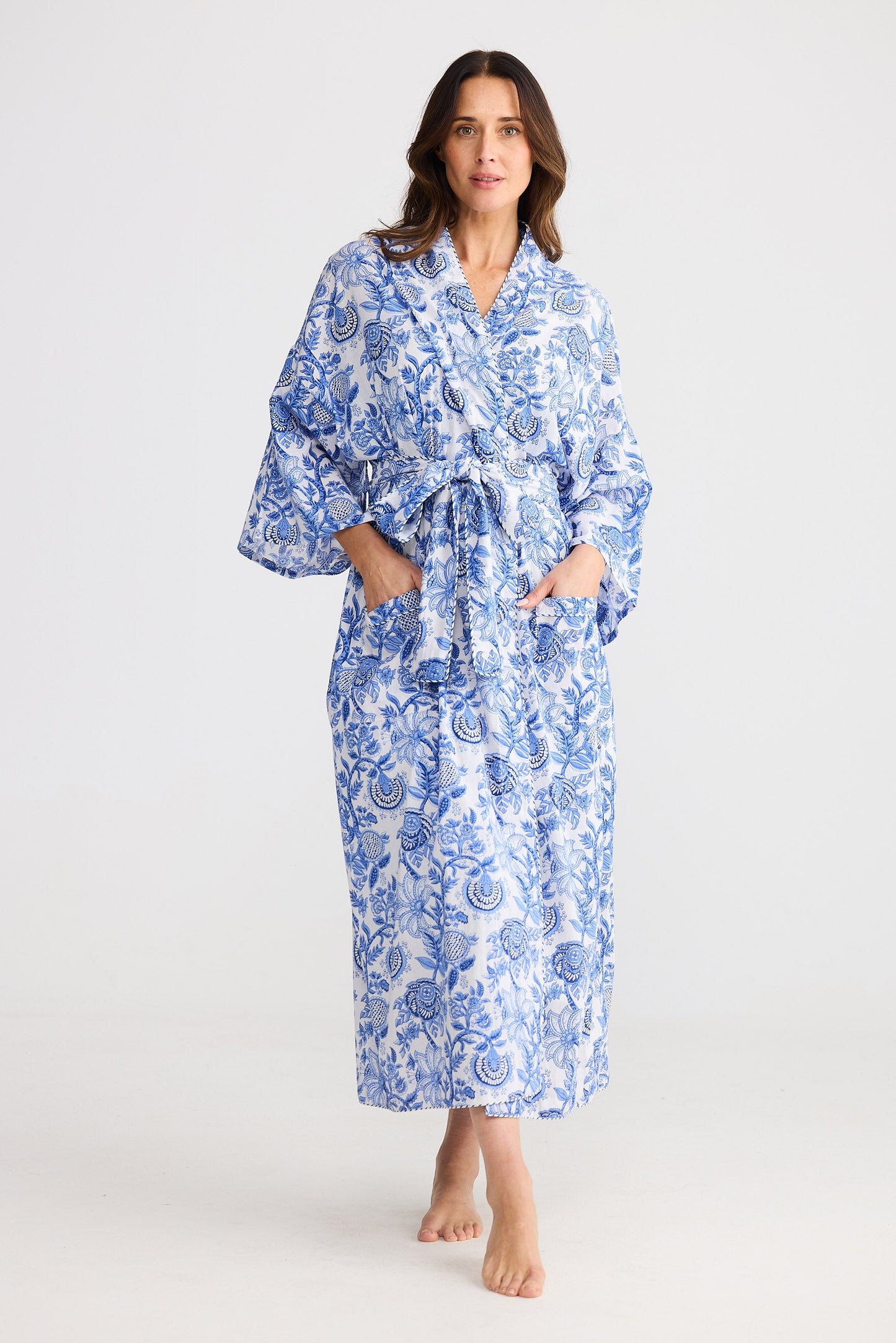 Woman wearing a blue floral robe on a white background