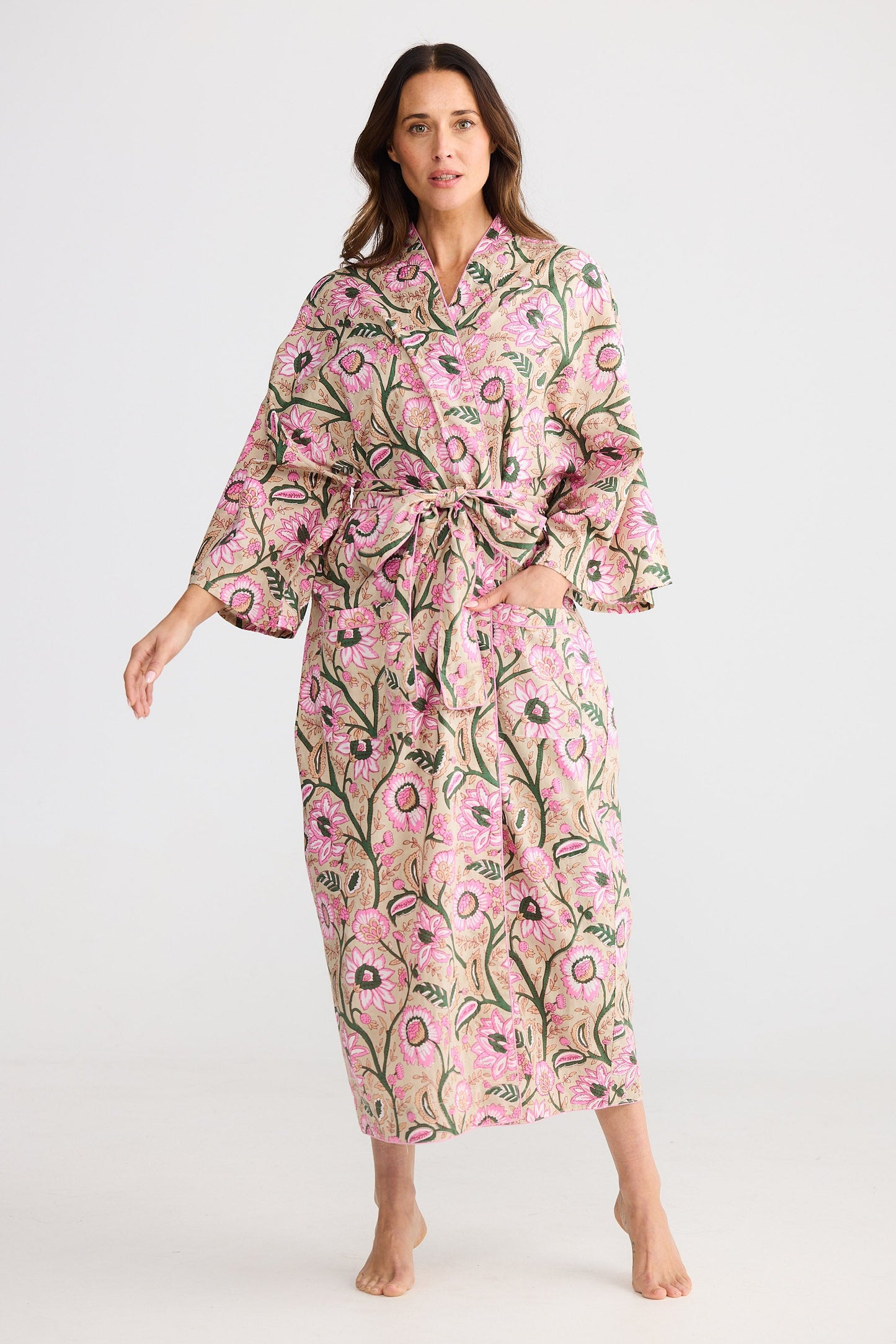 Woman wearing a floral pink robe on a white background