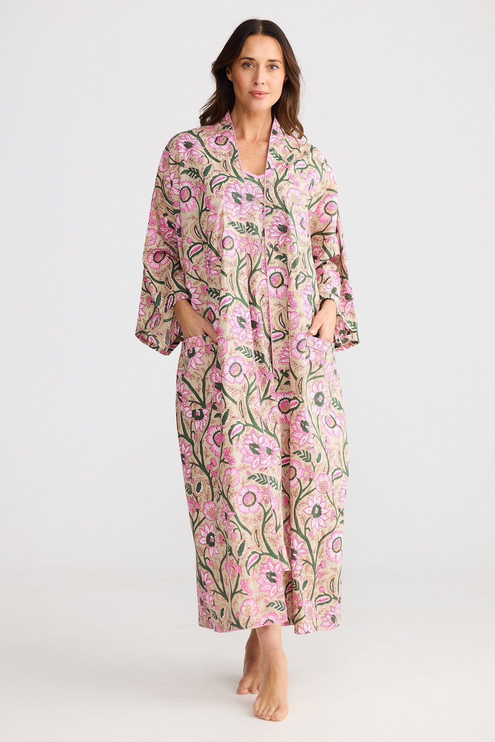 Woman wearing a pink floral robe on a white background
