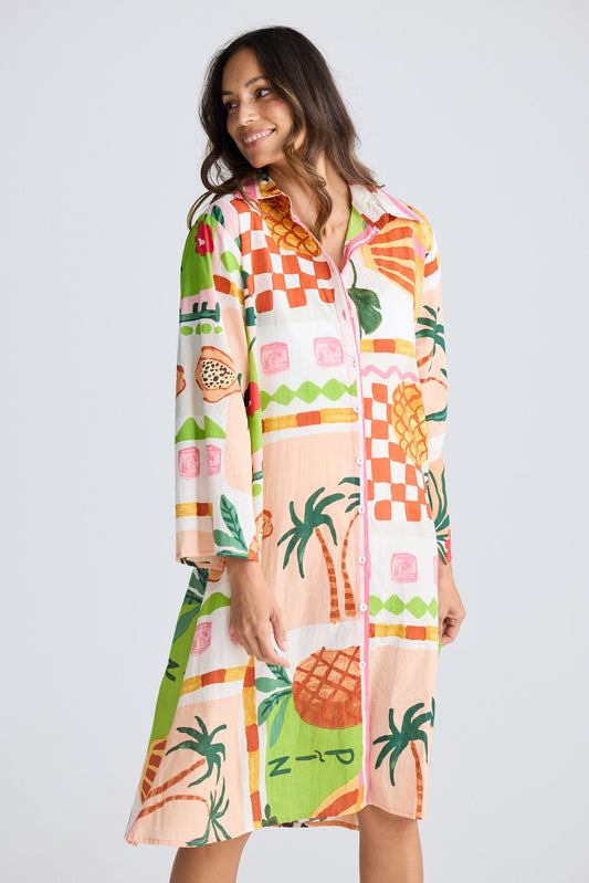 Woman wearing a colorful dress with pineapple pattern on a white background