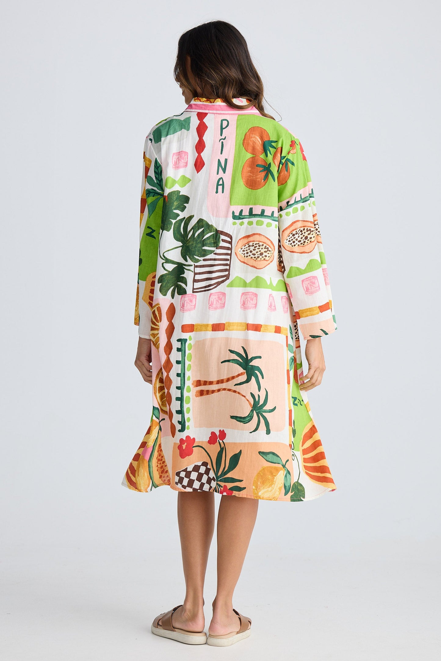 Woman wearing a colorful patterned dress on a white background