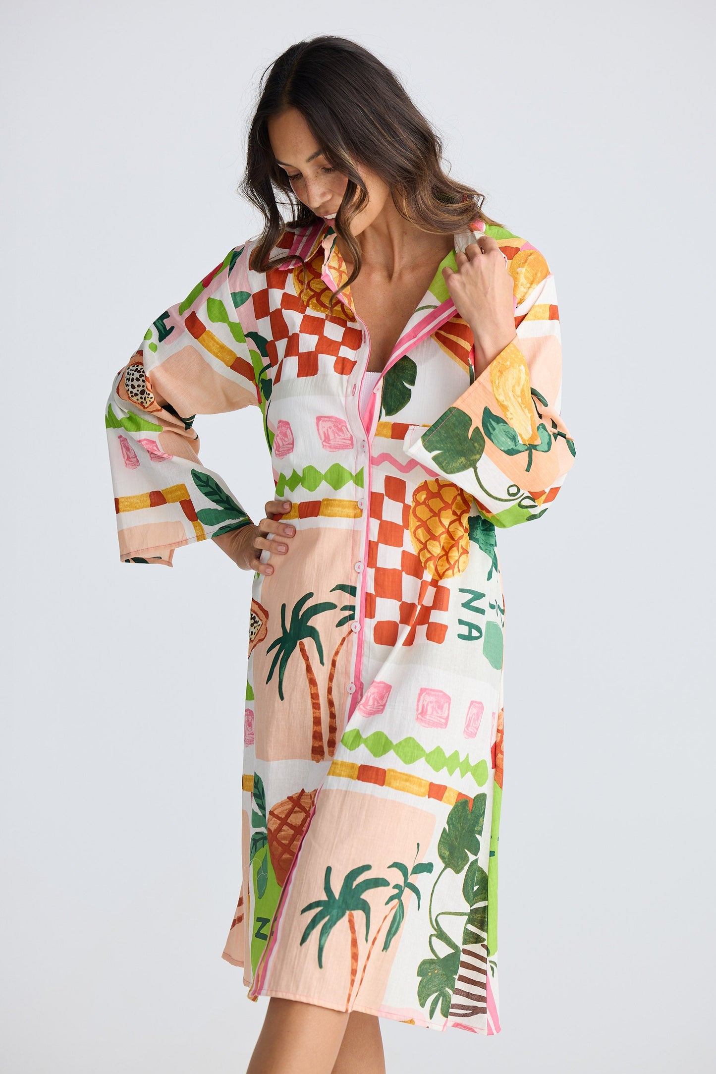 Woman wearing a colorful tropical patterned dress on a white background
